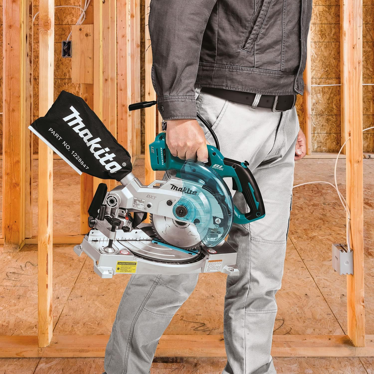 Un hombre sosteniendo una sierra eléctrica en un sitio de construcción con marco de madera.