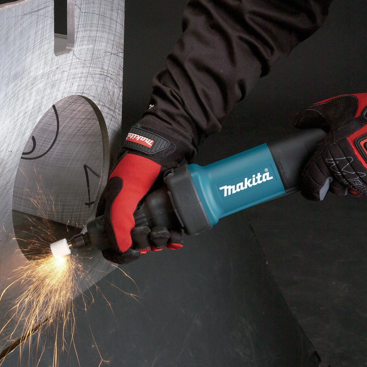 Ręka szlifuje metal, iskry lecą. Narzędzie Makita, osoba w czerwonych rękawicach.