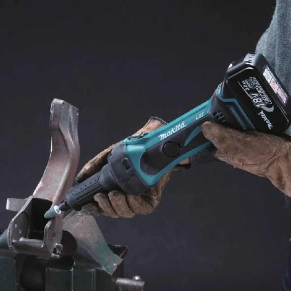 Osoba używa narzędzia Makita LXT. Narzędzie jest turkusowo-czarne i szlifuje metalowy element.