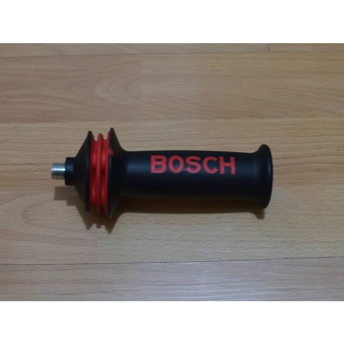 Mango Bosch negro con detalles rojos, sobre una superficie de vetas de madera.
