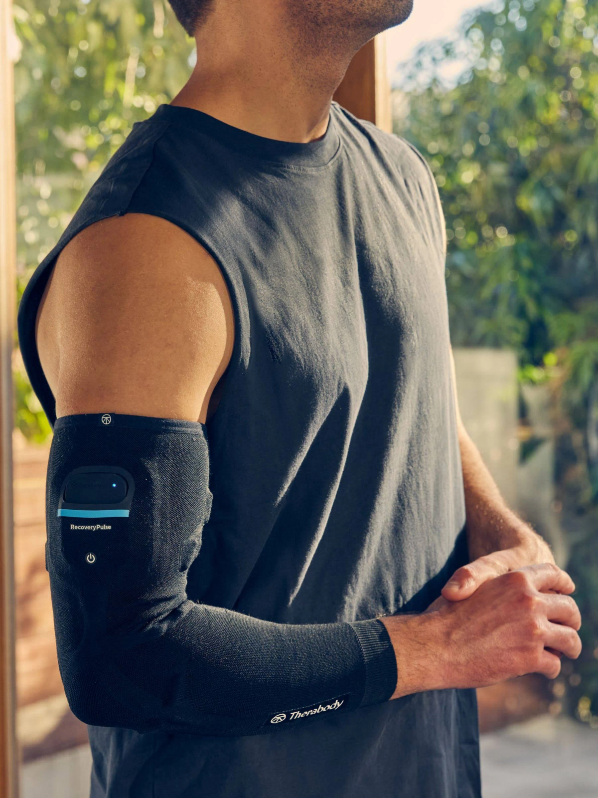Hombre con manga negra con dispositivo de pulso de recuperación azul. Fondo de ventana clara.