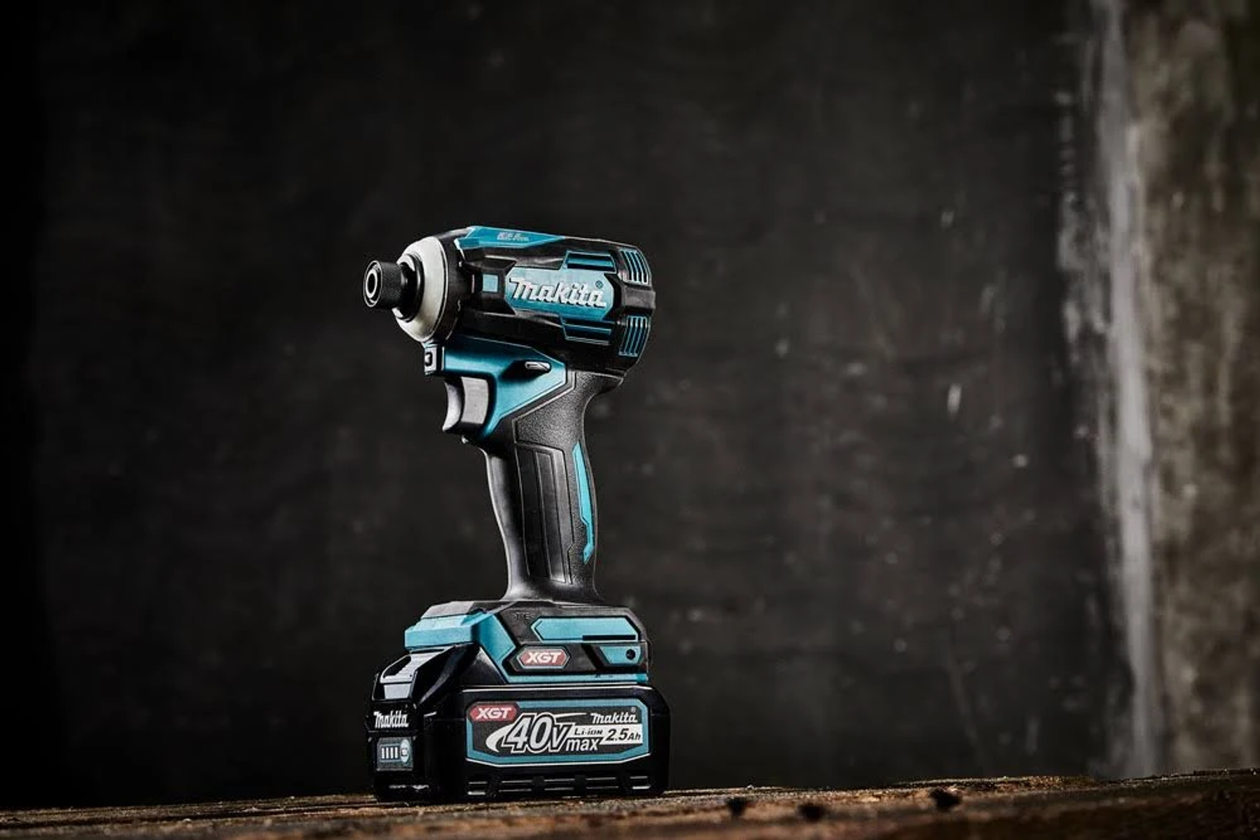 Avvitatore a impulsi Makita, nero, verde acqua e nero. Batteria in basso e su una superficie di legno.