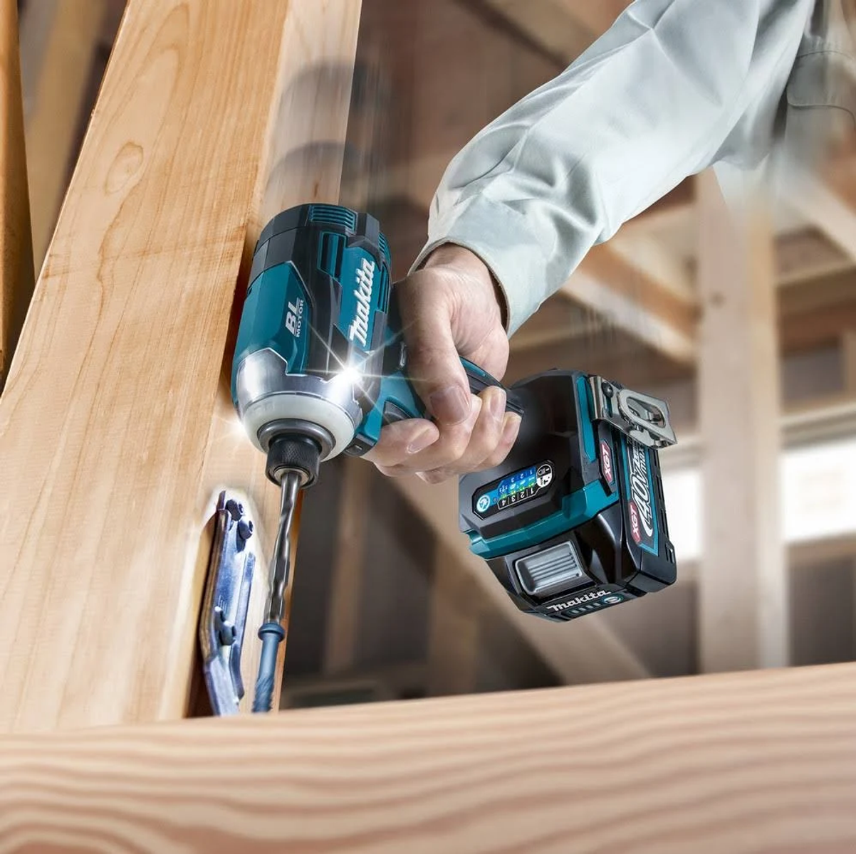 Persona che usa un avvitatore a impulsi Makita su un telaio in legno. Utensile turchese e nero.