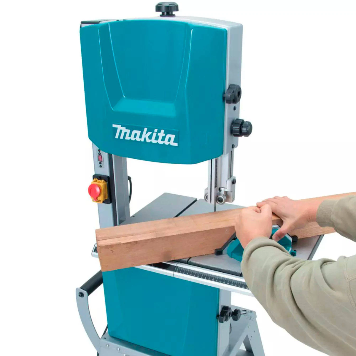 Eine Makita Bandsäge schneidet Holz. Eine Person hält das Holz auf dem Sägetisch.