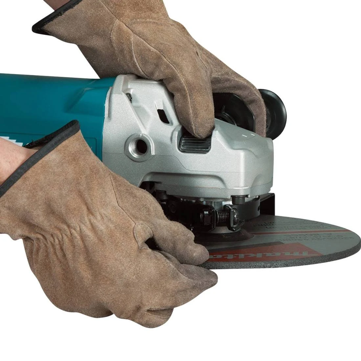 Manos con guantes marrones sujetando una amoladora Makita, mostrando la cuchilla.