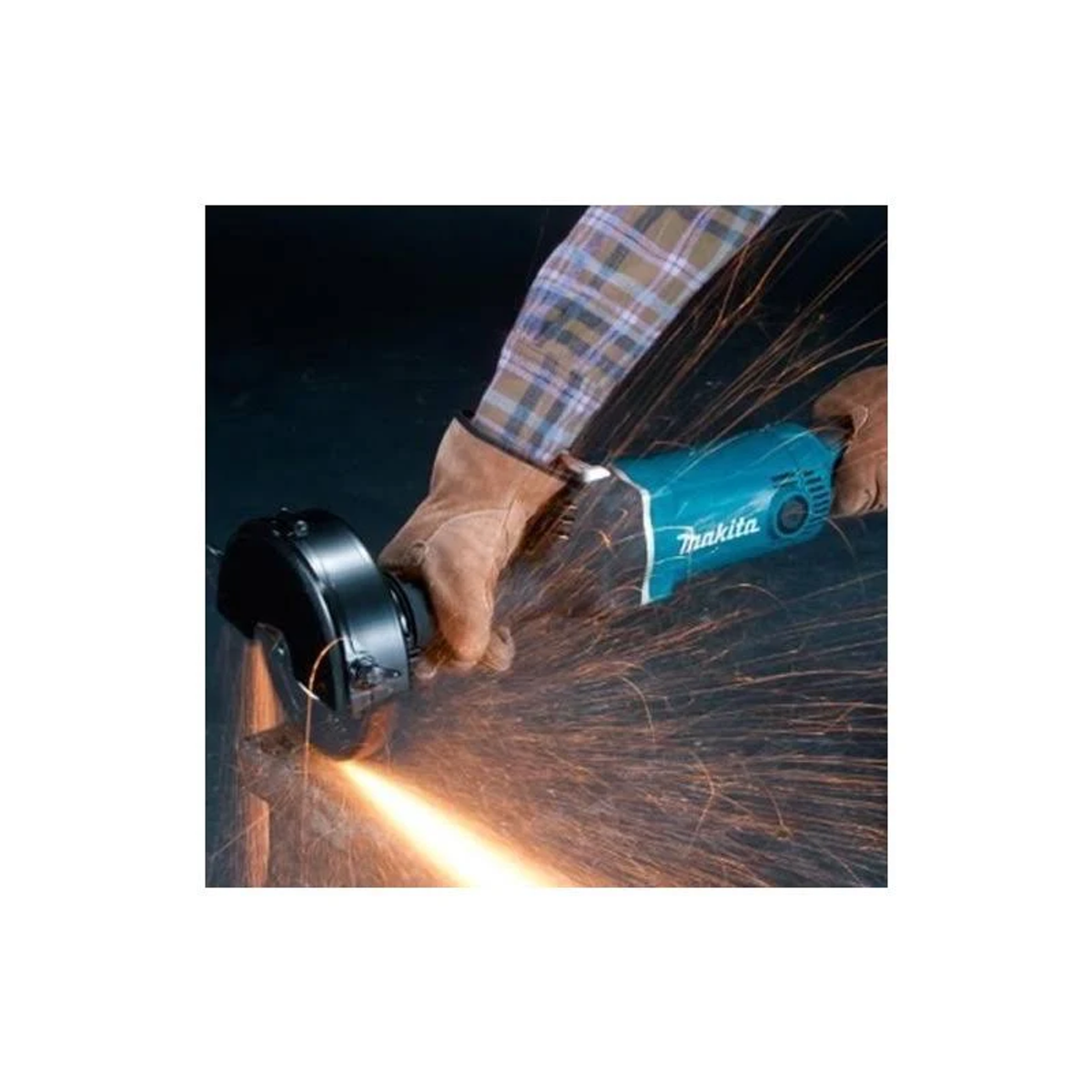Una persona usando una amoladora Makita, chispas volando, en un entorno oscuro.
