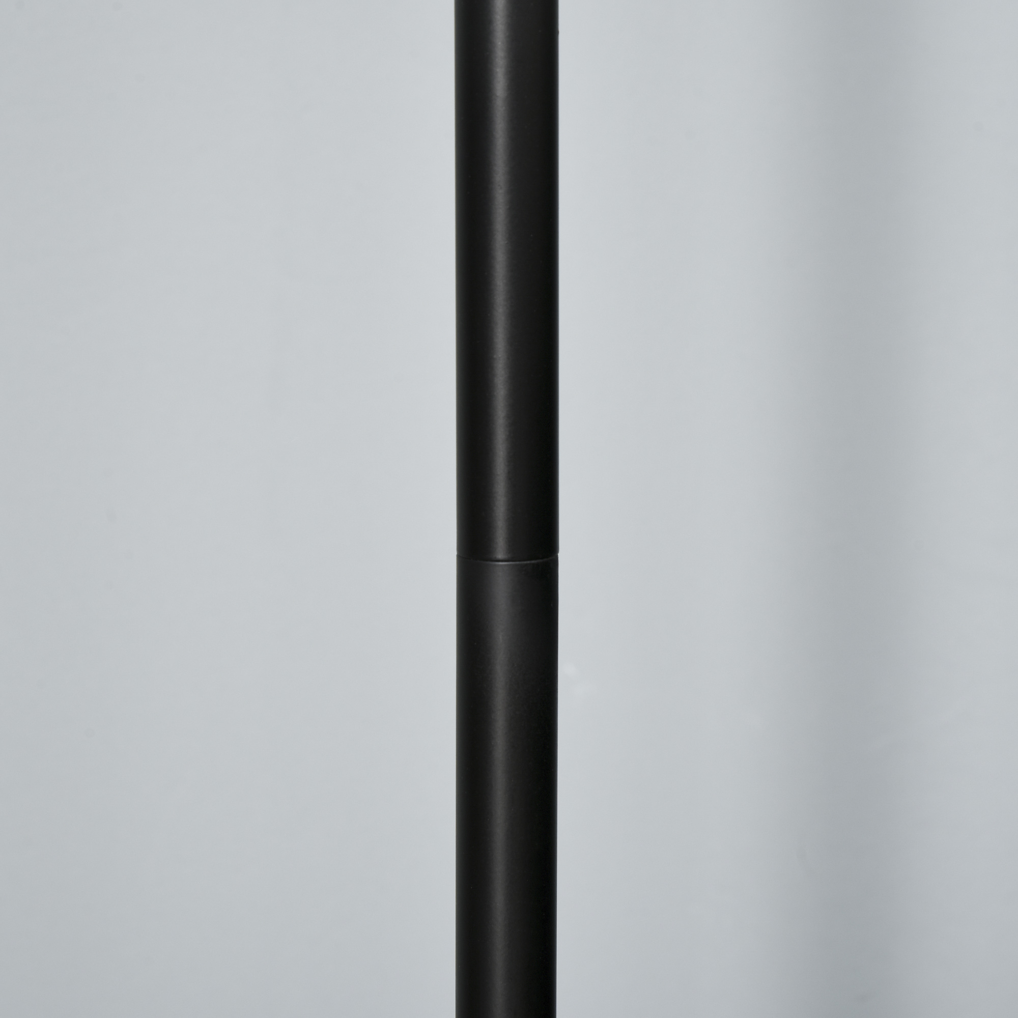 Primo piano di un palo della lampada nero. Il palo è cilindrico e liscio.