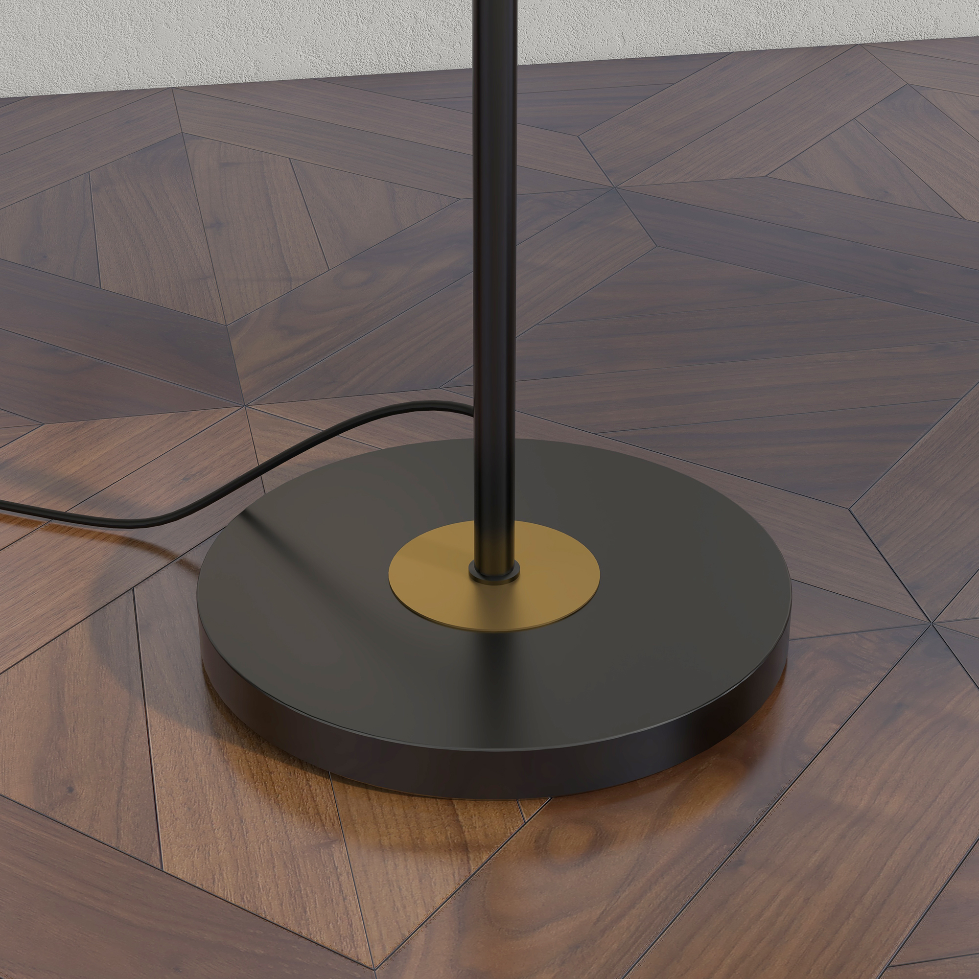 Primo piano di una base di lampada nera con un accento dorato su un pavimento in legno.