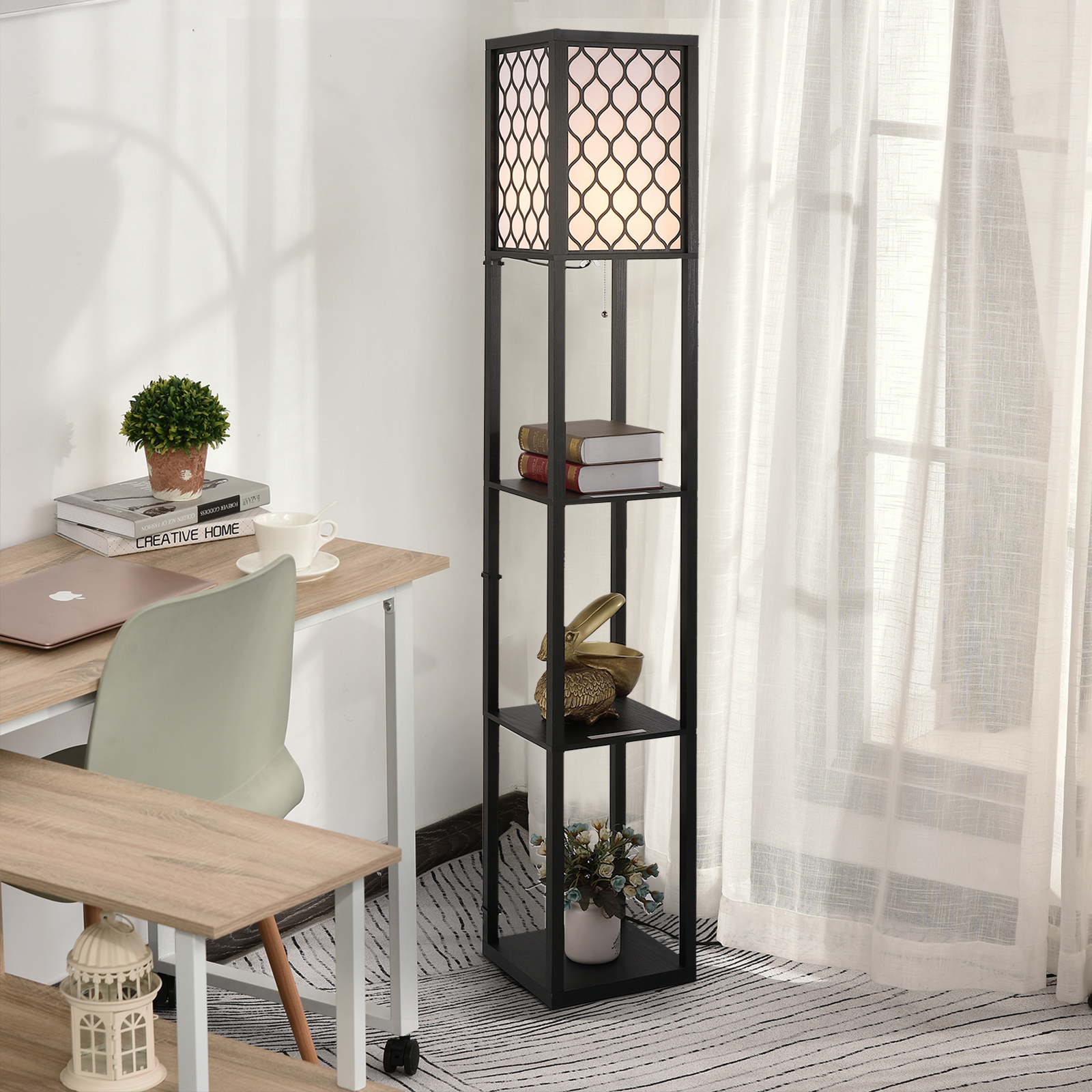 Lampada da terra nera con mensole, libri e decorazioni. Una scrivania a sinistra.
