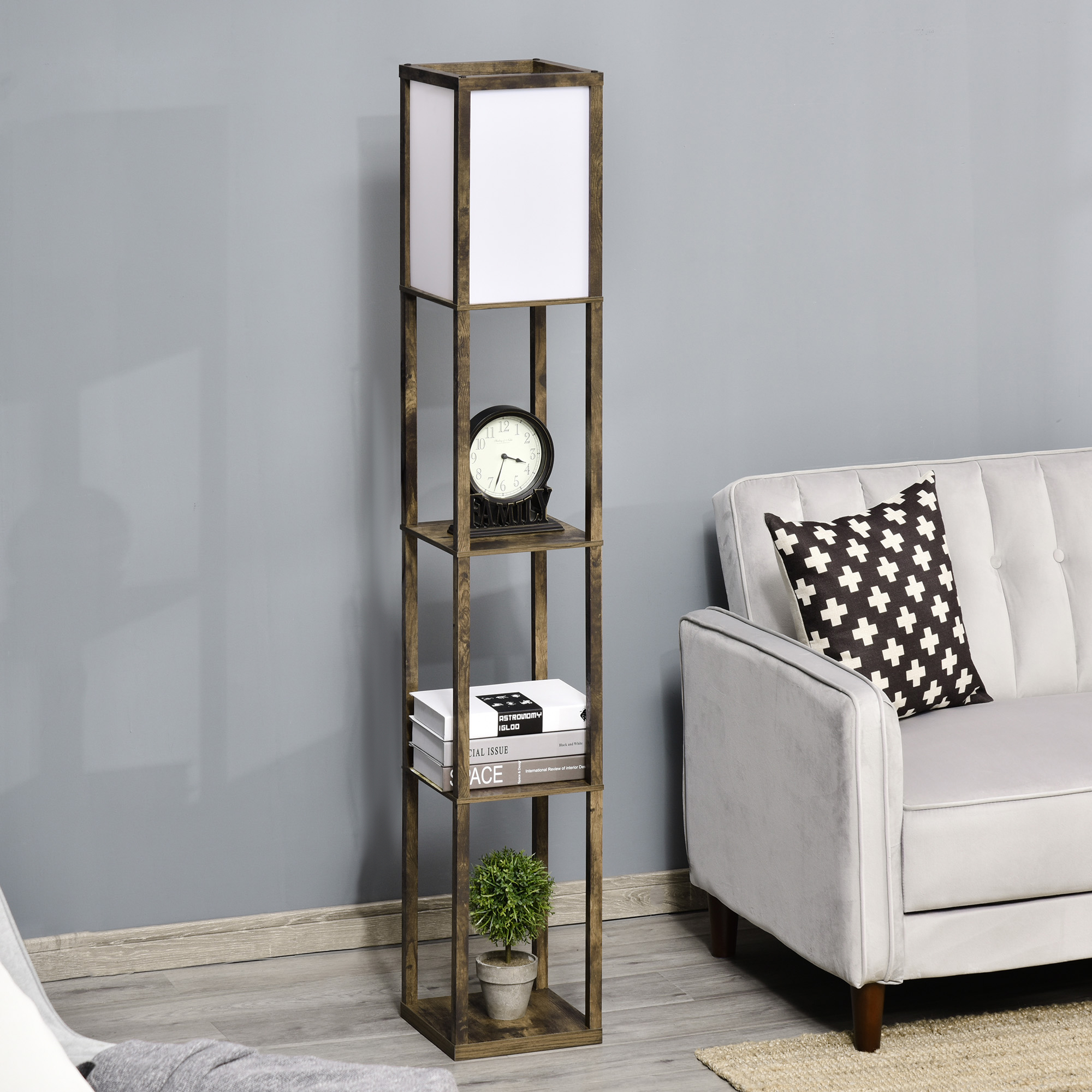 Lampada da terra alta in legno con mensole, libri, orologio e pianta accanto al divano.