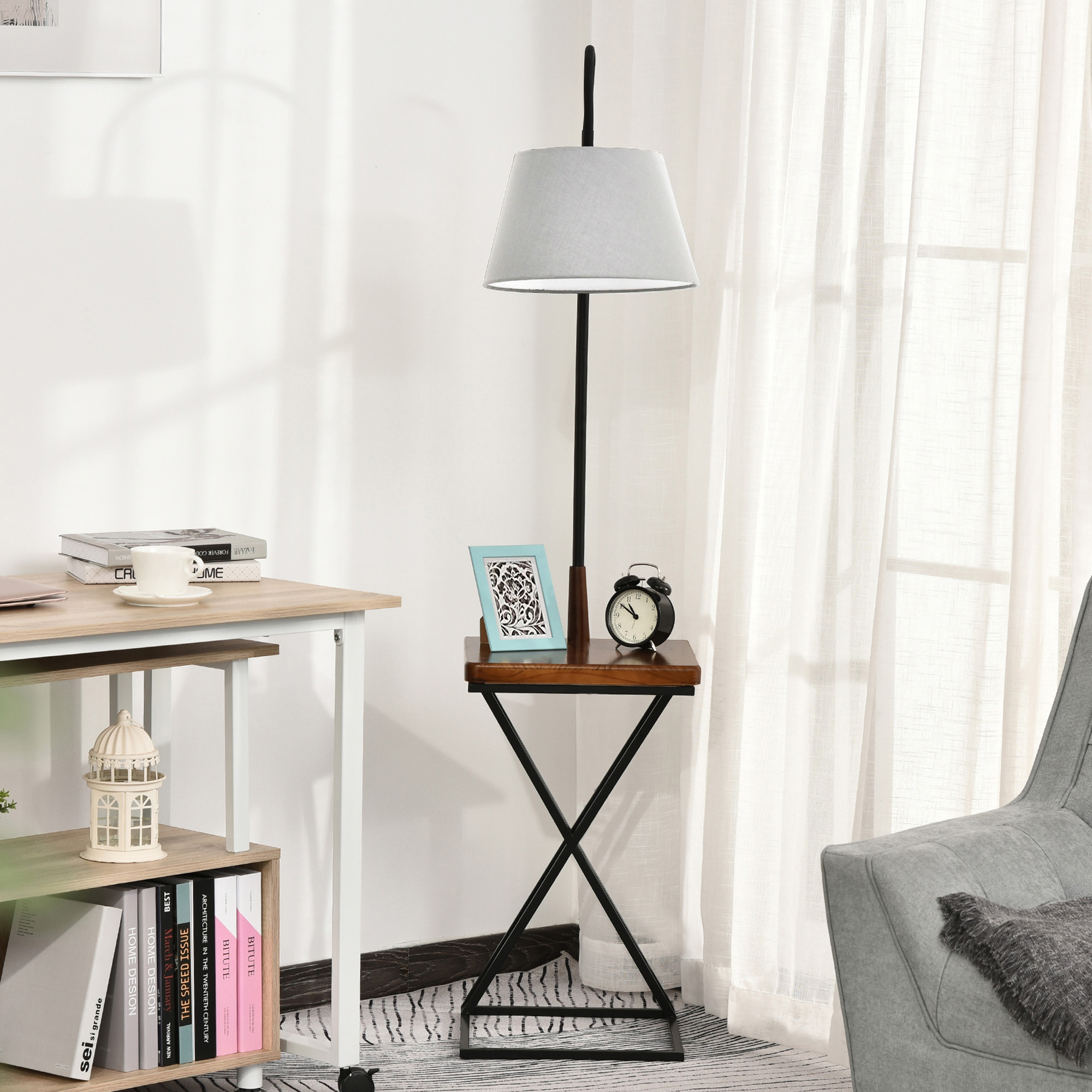 Una lampada con un tavolino. C'è una scrivania con libri e una gabbia decorativa sullo sfondo.