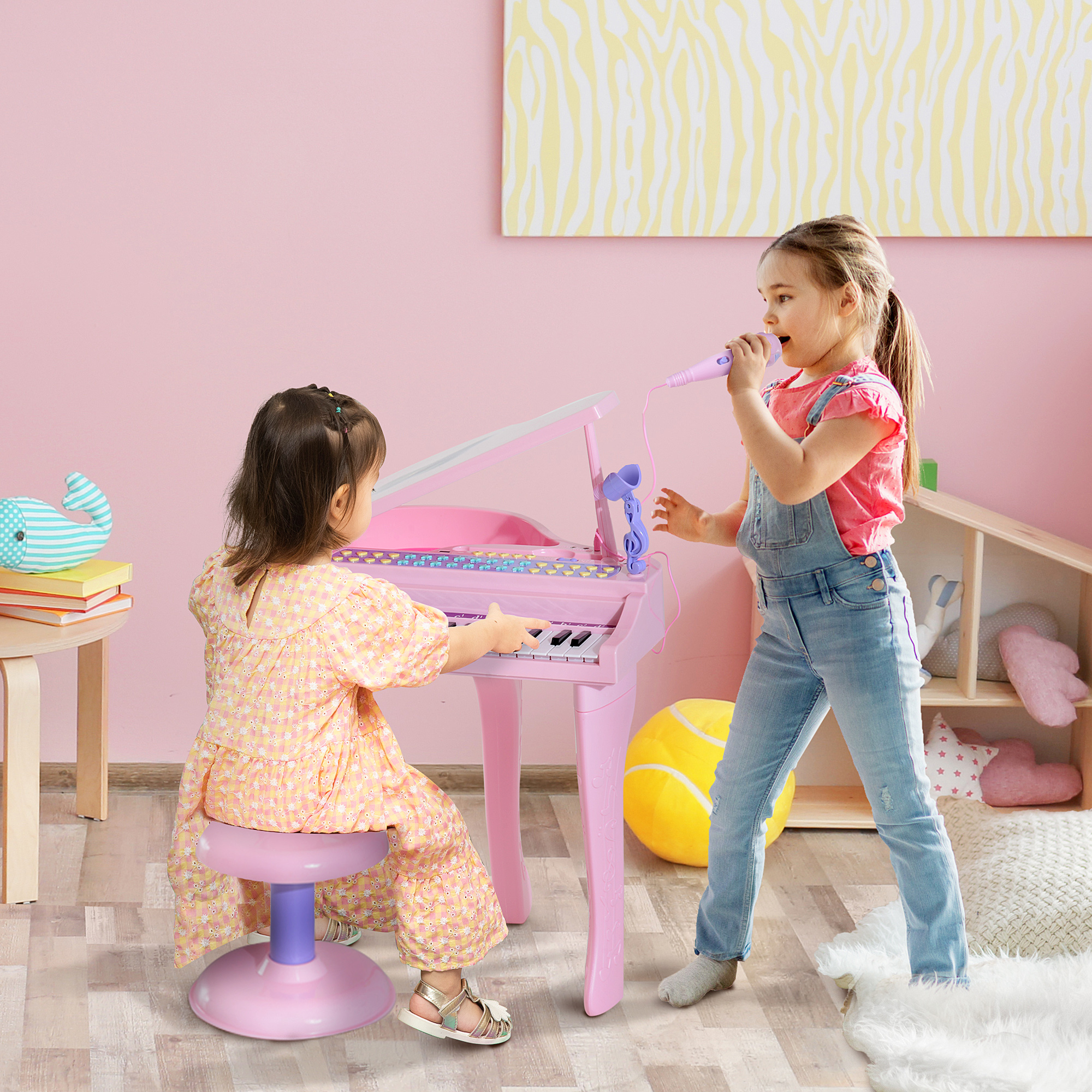 Due ragazze suonano un pianoforte rosa, una canta in un microfono in una stanza rosa.