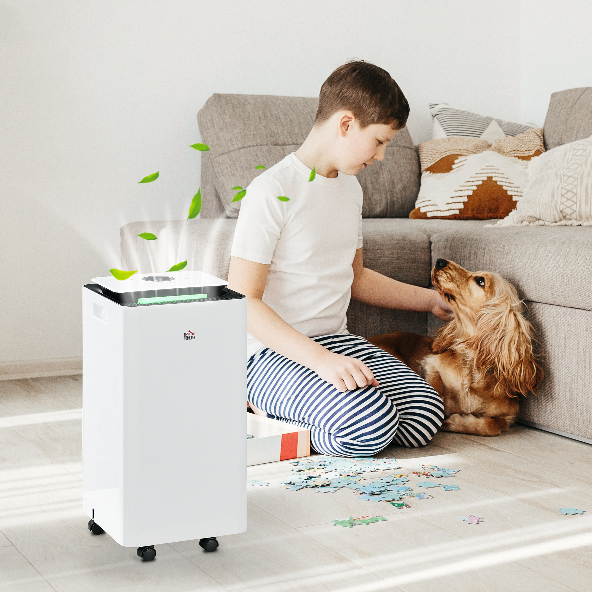 Un ragazzo con un cane e un purificatore d'aria bianco. Il purificatore ha foglie verdi.
