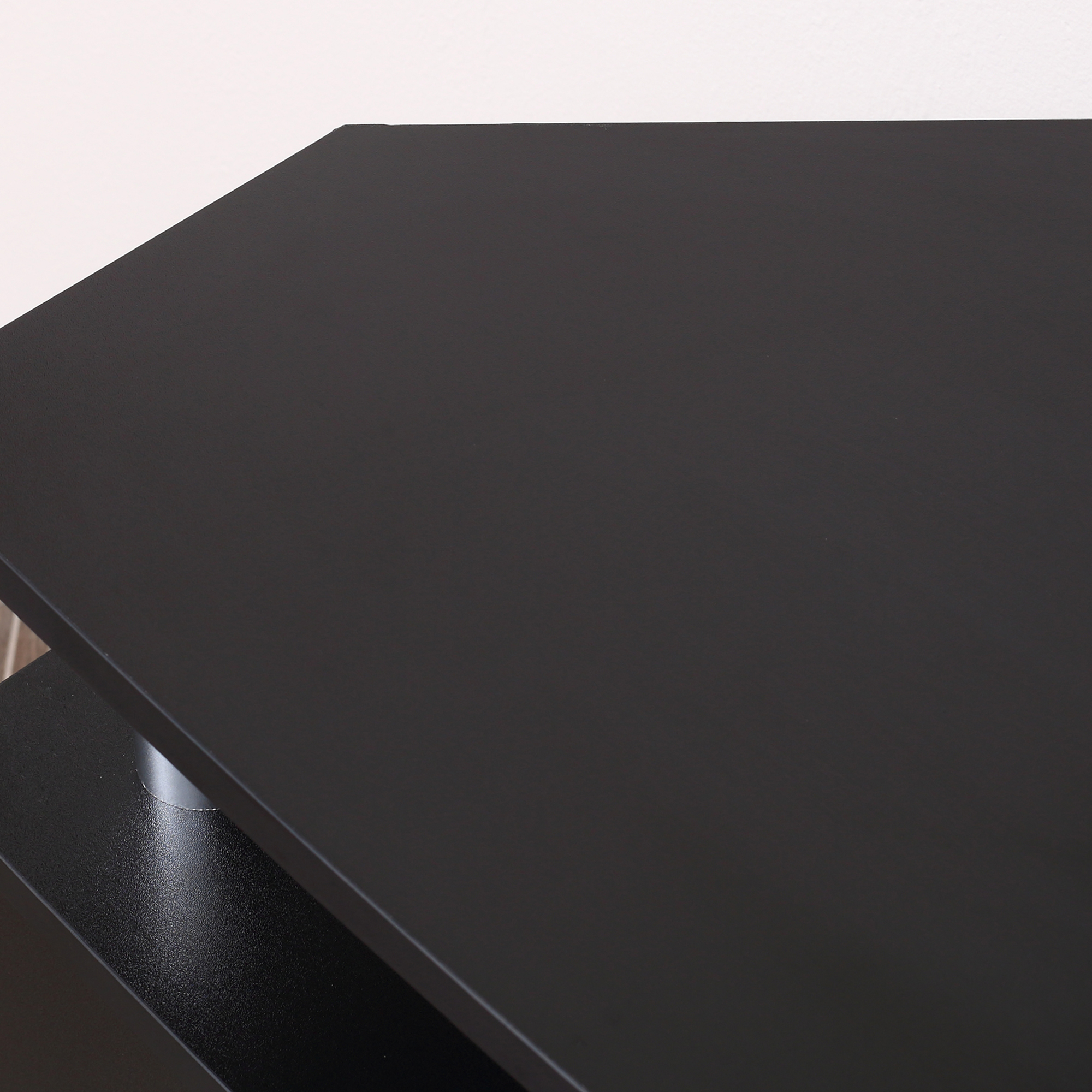 Un primo piano di un tavolo nero. La superficie è liscia e riflettente.