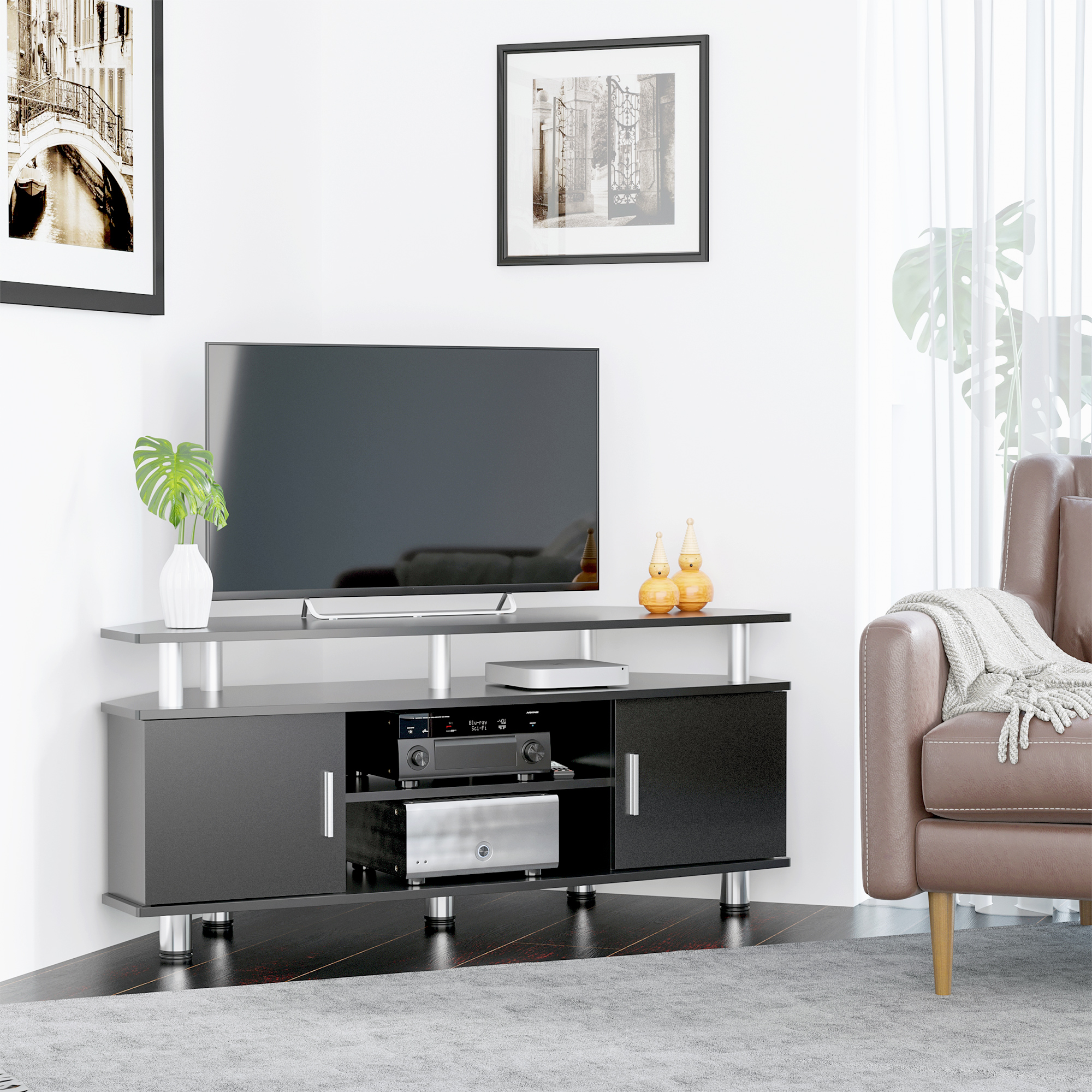 Un mobile TV nero con una TV sopra. Ci sono due dipinti sullo sfondo.