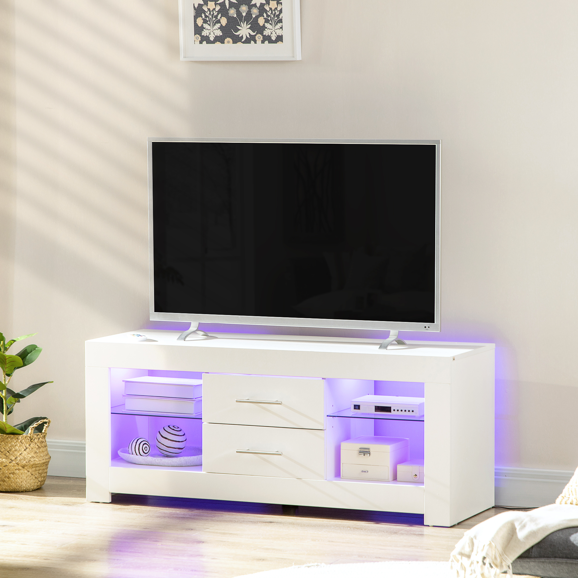 Un mobile TV bianco con cassetti e ripiani, una TV sopra. Illuminato con luci viola.