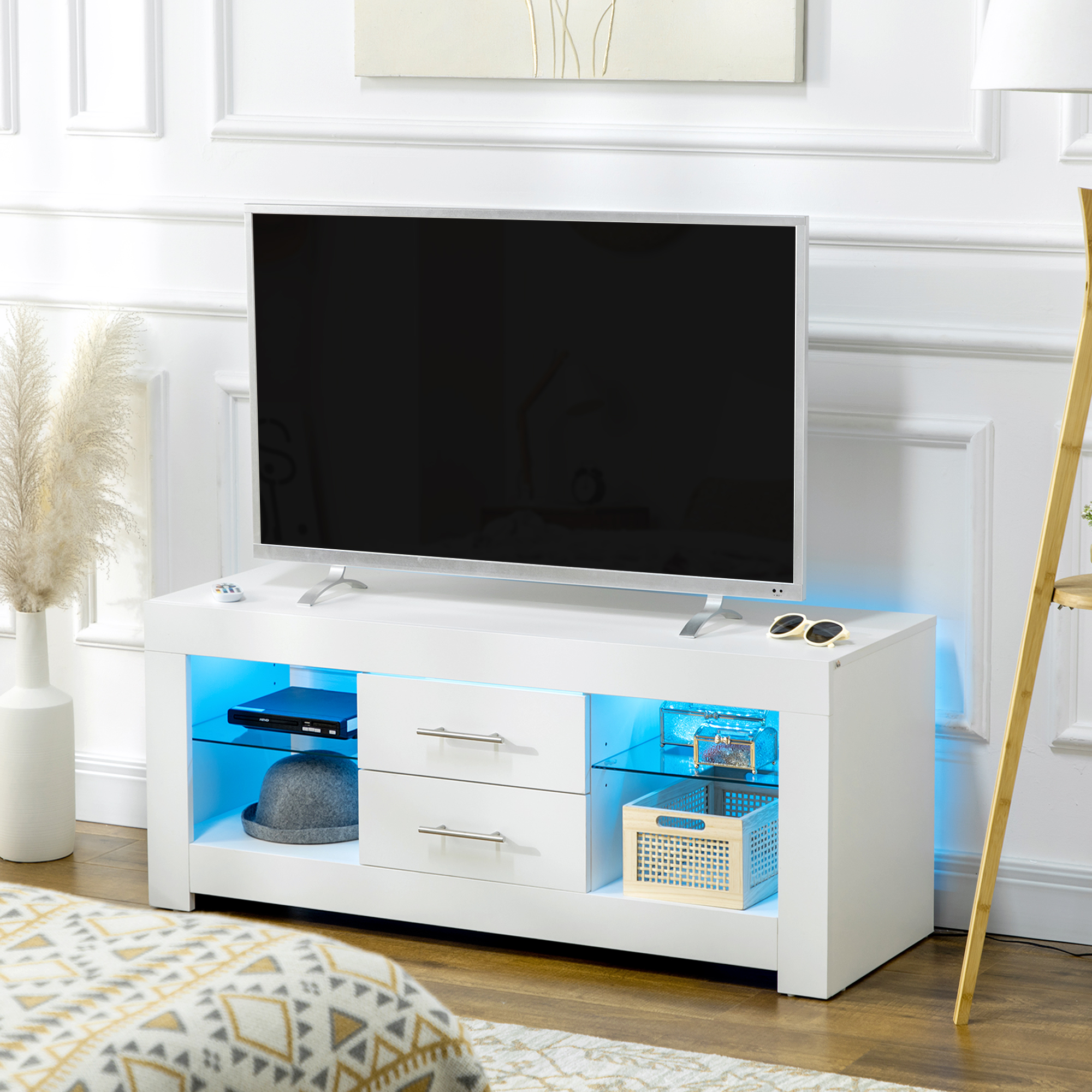 Un mobile TV bianco con una TV. Ci sono ripiani in vetro con luci blu.