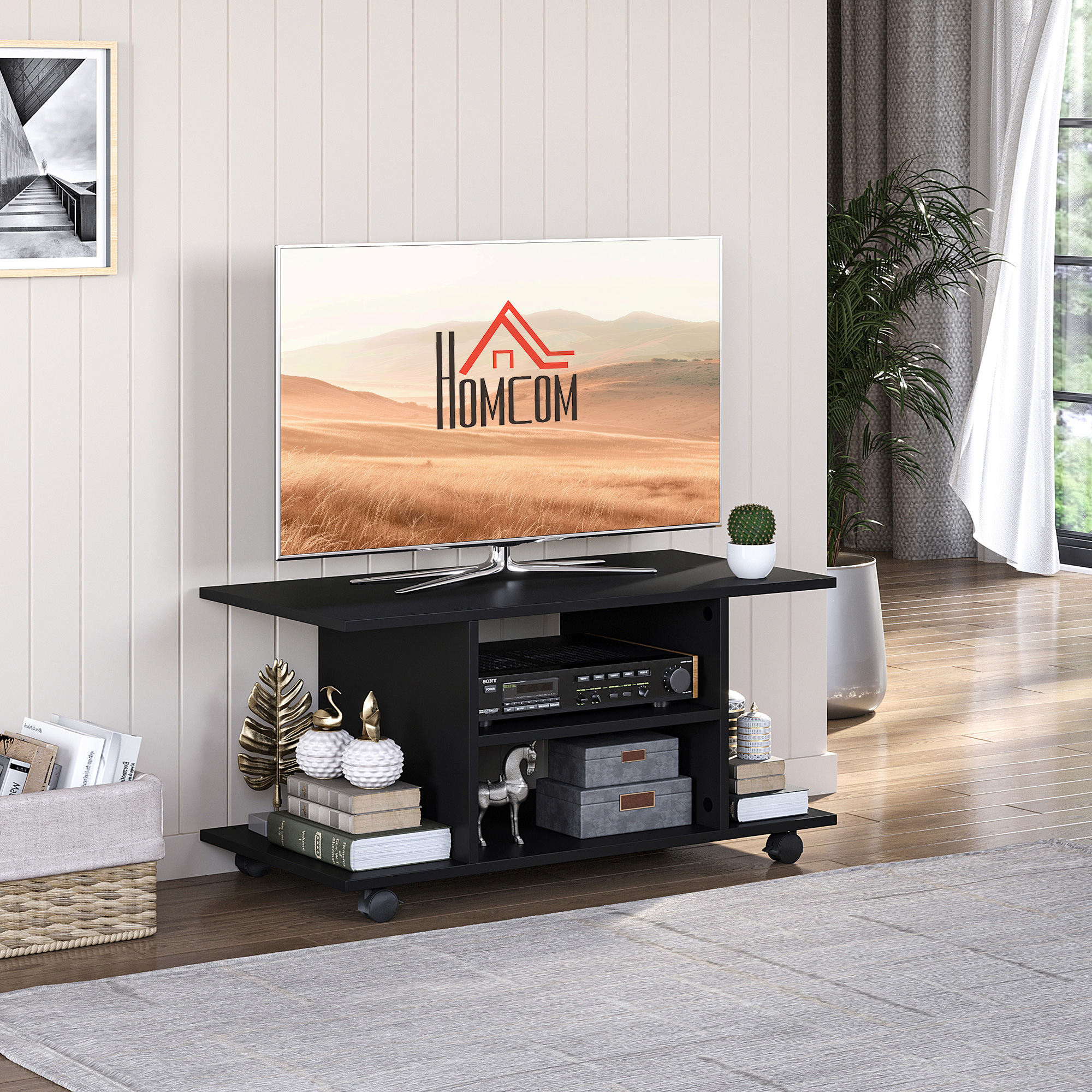 Mobile TV nero con TV sopra. Decorazioni e libri sono posizionati sul supporto.