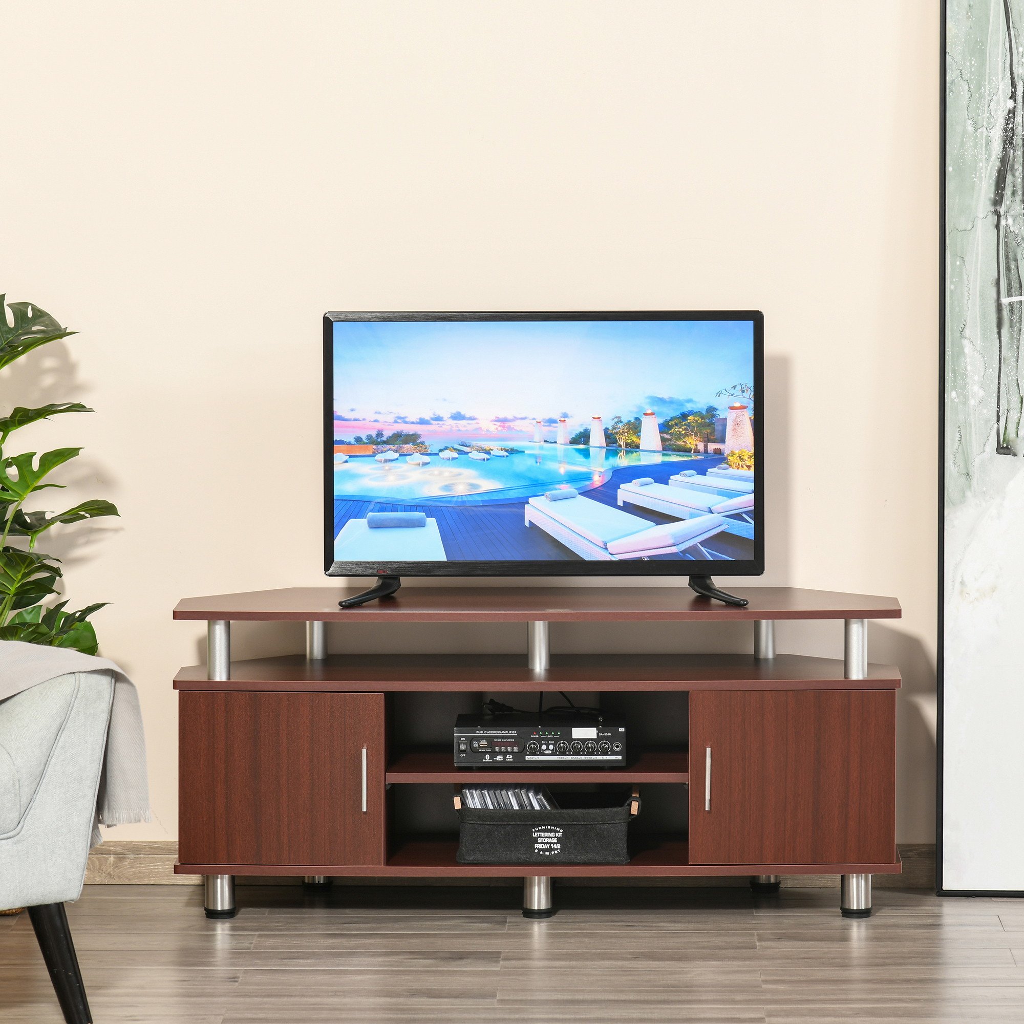Un mobile TV marrone con una TV. C'è una scatola nera e decorazioni.