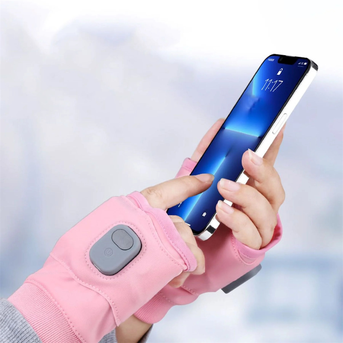 Person benutzt rosa Handschuhe mit Knopf. Ein Telefon mit Bildschirm ist im Fokus.