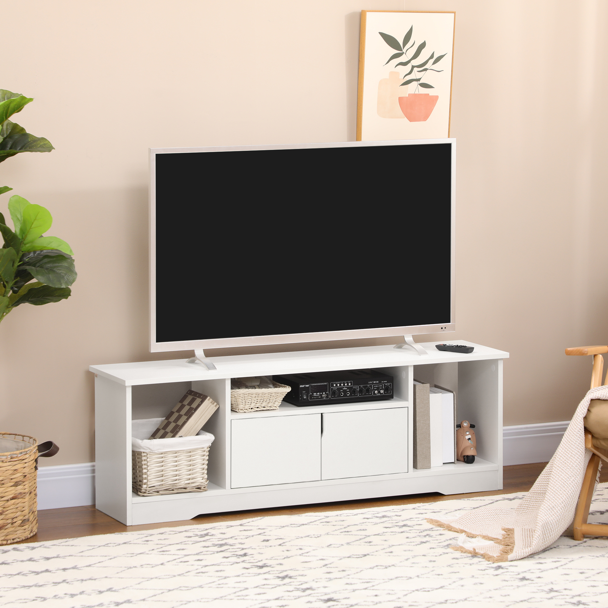 Un mobile TV bianco con un televisore. Ci sono libri e decorazioni. Un tappeto e un dipinto sullo sfondo.