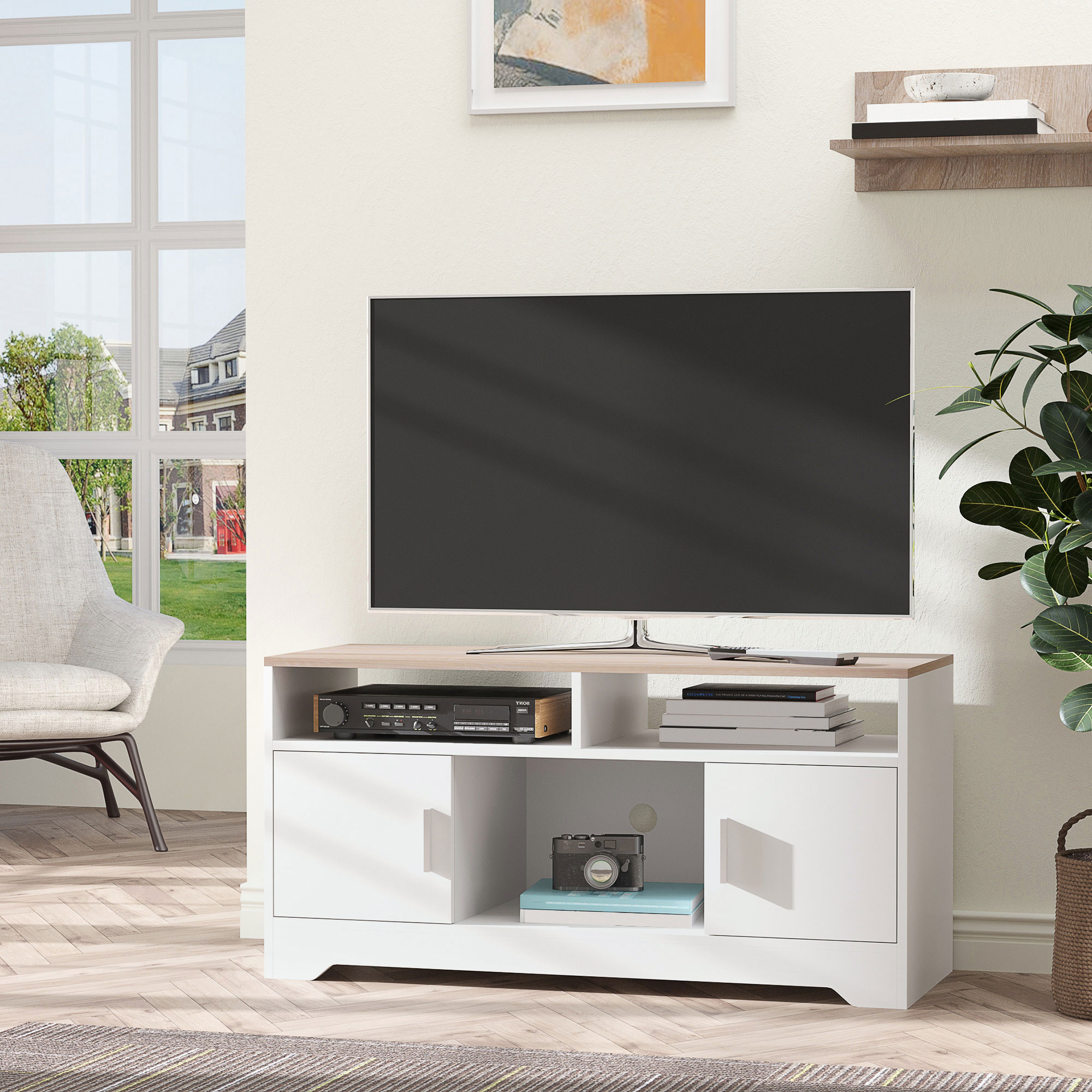Una TV su un mobile TV bianco e legno con decorazioni, una finestra e una sedia.