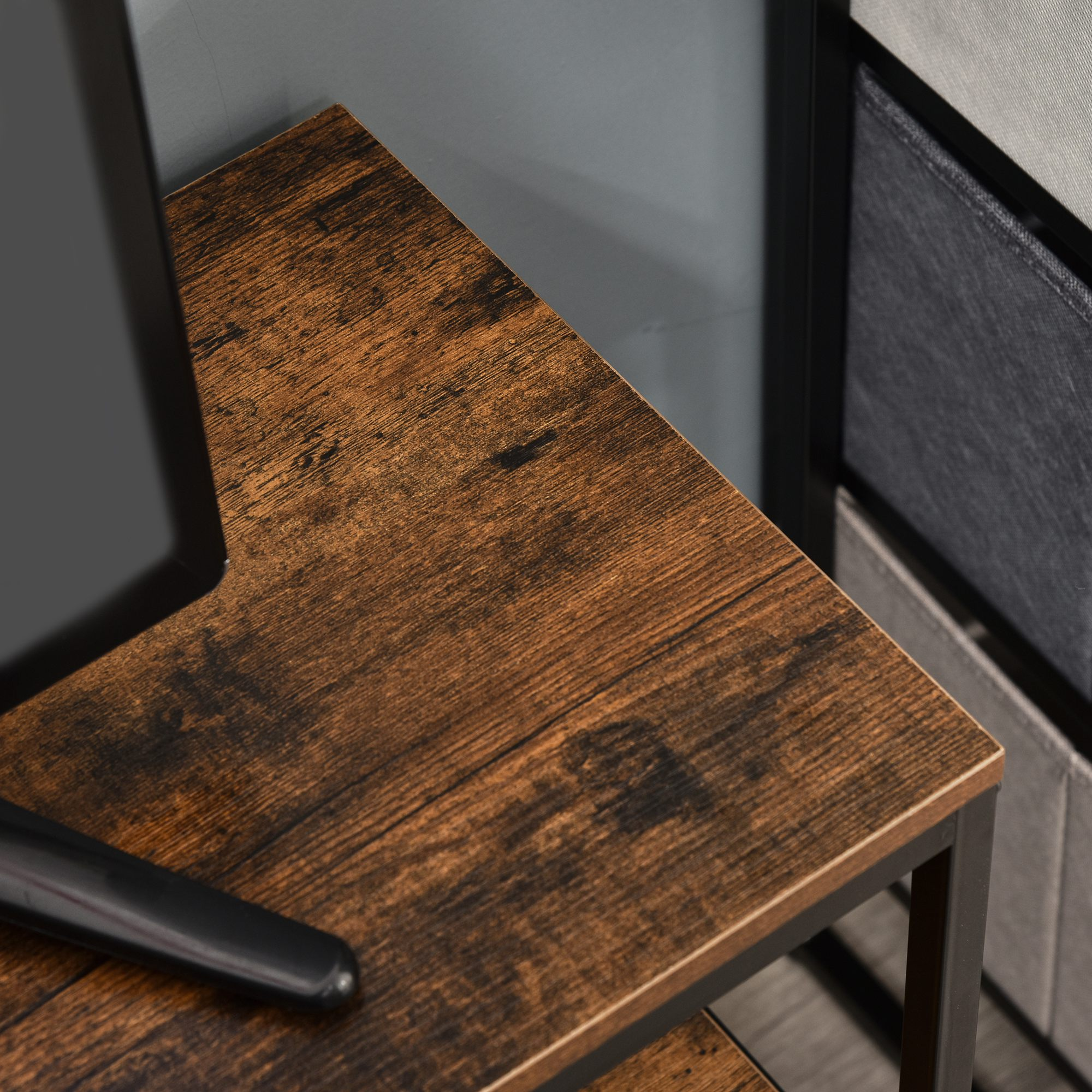 Primo piano dell'angolo di un mobile TV, con venature del legno, cornice in metallo nero e tessuto grigio.