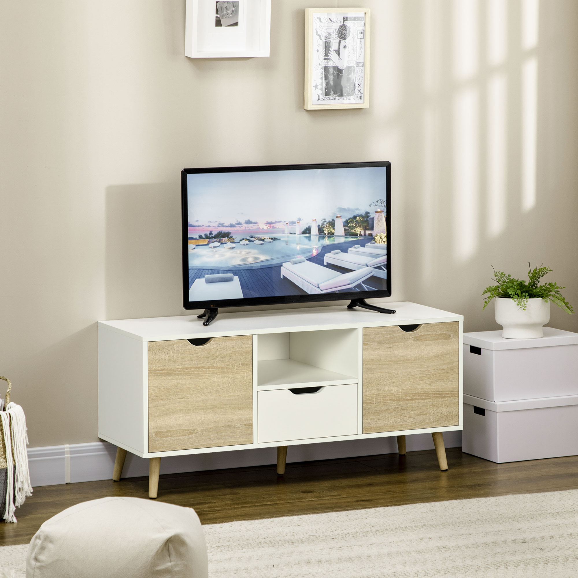 Una TV su un mobile TV bianco e color legno. Ci sono decorazioni sul lato.