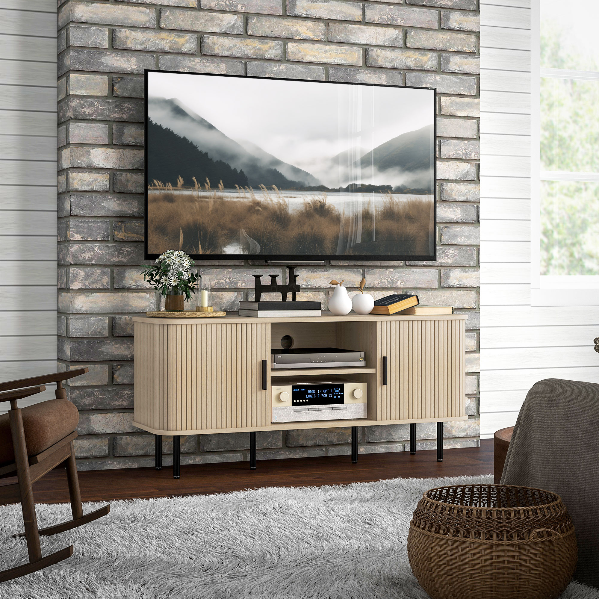 Un mobile TV in legno chiaro con una TV sopra. Un muro di mattoni sullo sfondo. C'è un tappeto sul pavimento.