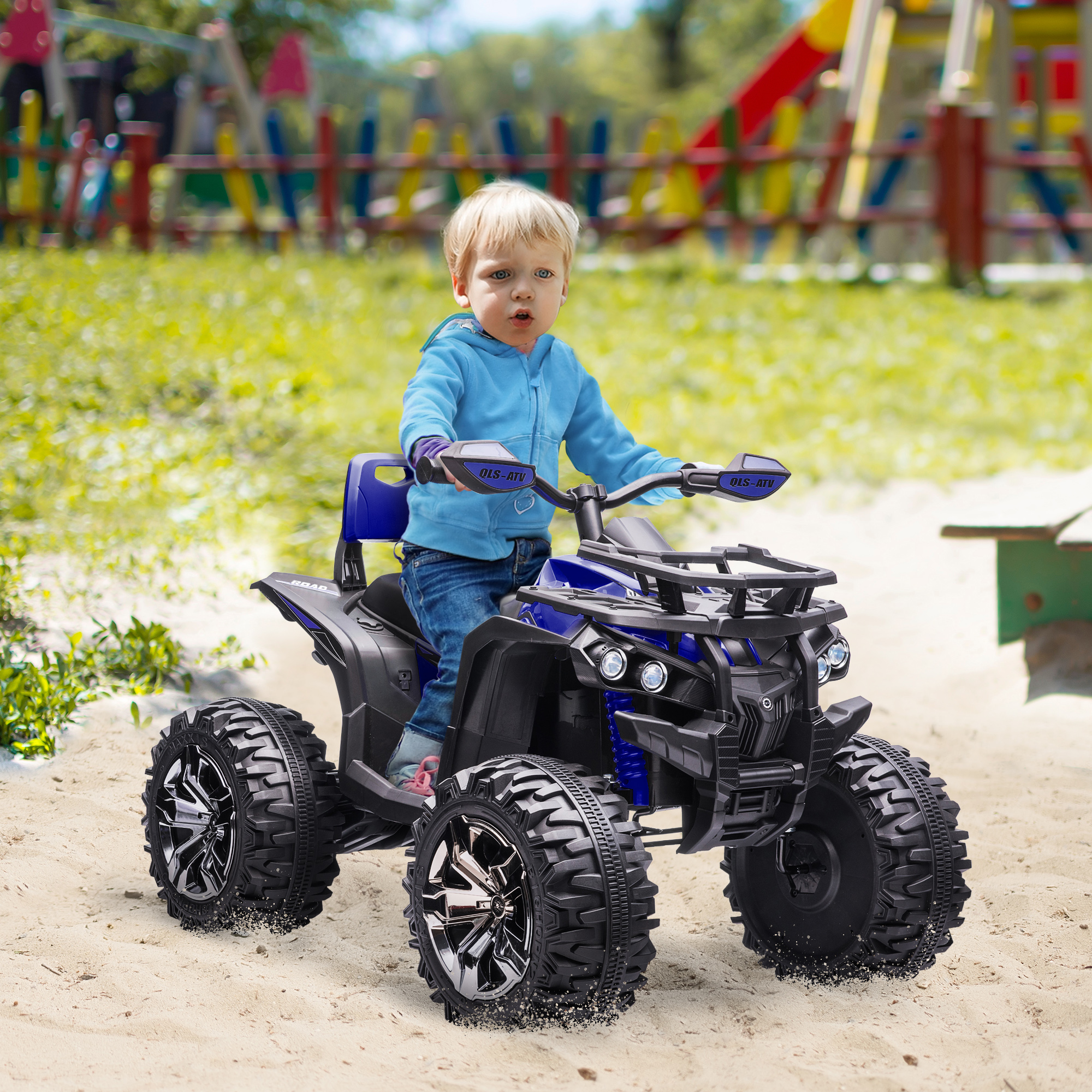 Un bambino che guida un quad giocattolo. Il bambino è sulla sabbia. Il quad è nero e blu.