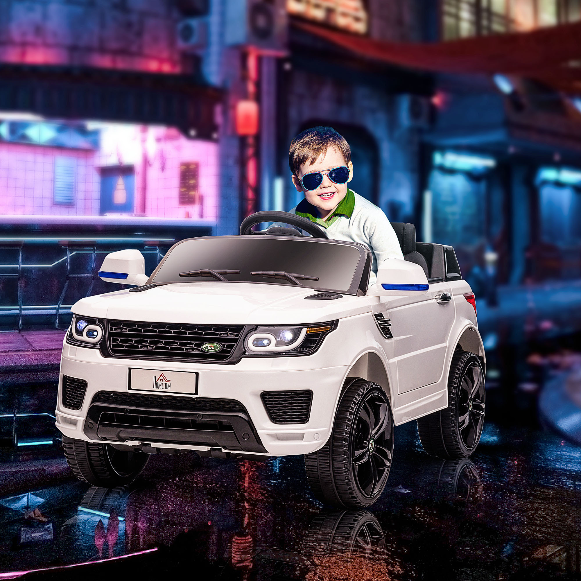 Un bambino con gli occhiali da sole guida un Range Rover giocattolo bianco. Lo sfondo mostra una città con luci al neon.