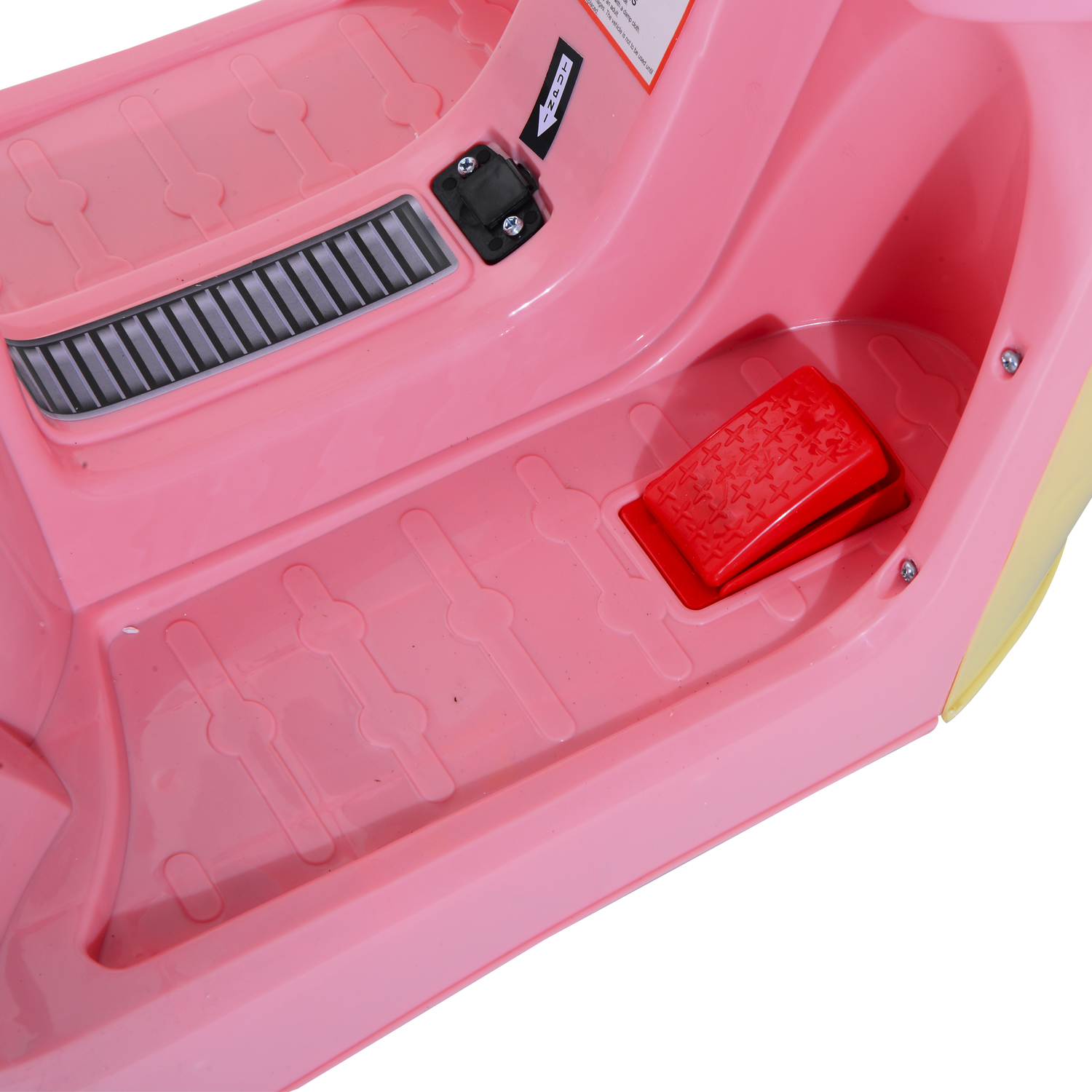 Interno rosa di un'auto giocattolo, con pedale rosso e bocchetta nera. Sfondo bianco.