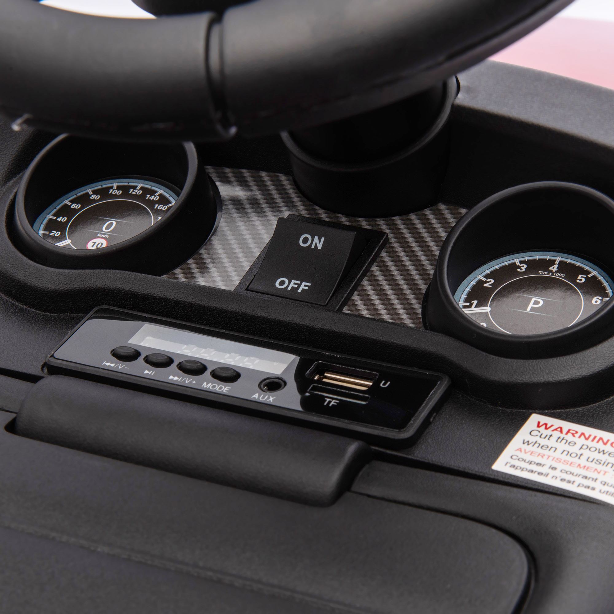Cruscotto di un'auto giocattolo con indicatori, pulsanti (ON/OFF) e display digitale.