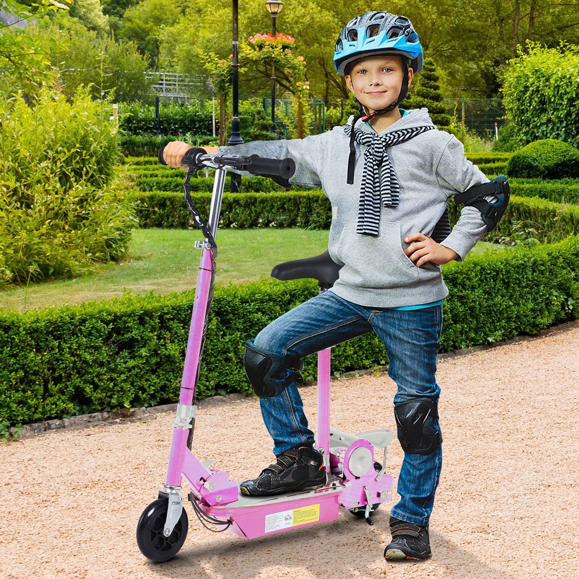Un ragazzo con casco e protezioni posa con un monopattino rosa. È in un parco.