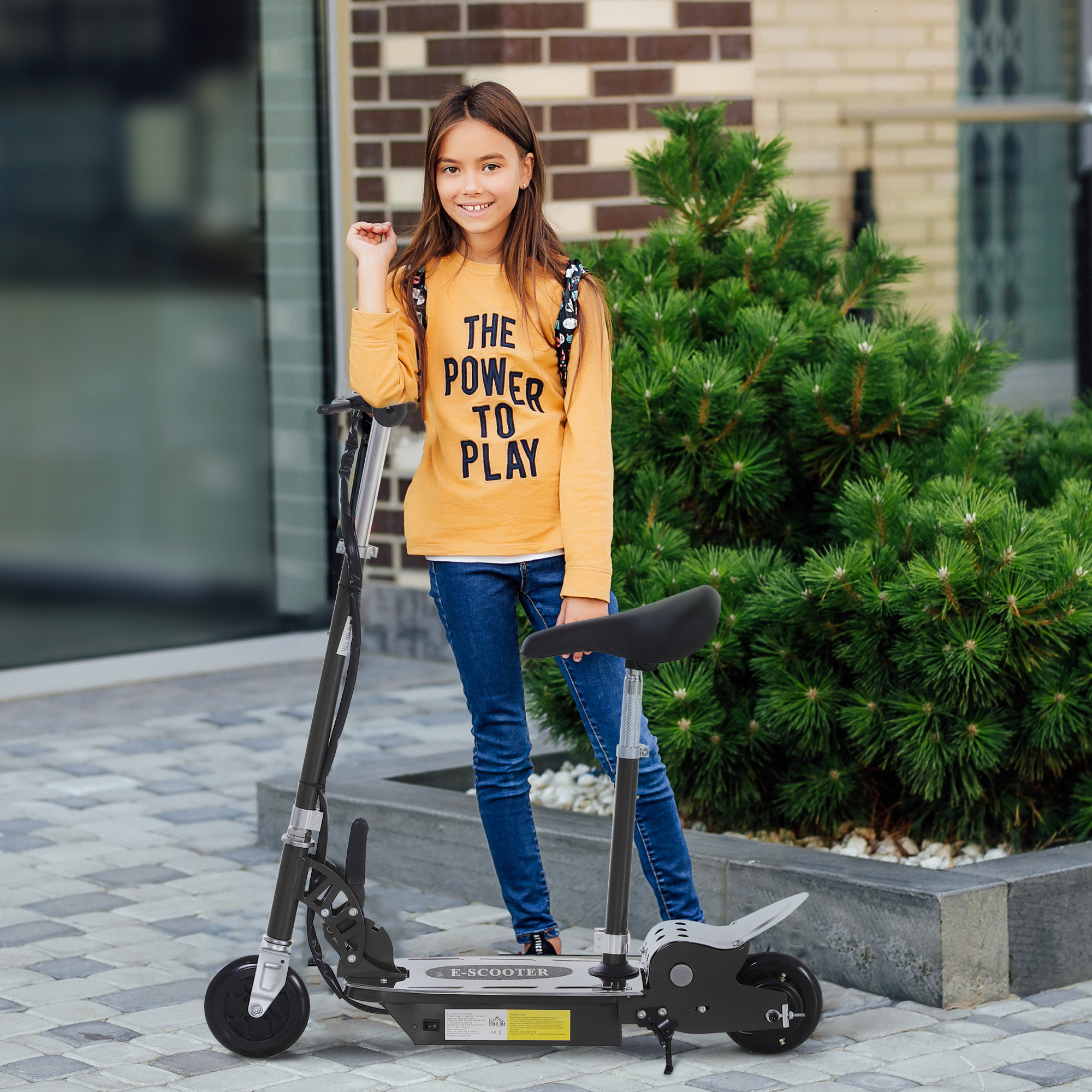 Una ragazza con una maglietta gialla accanto a uno scooter nero e argento.