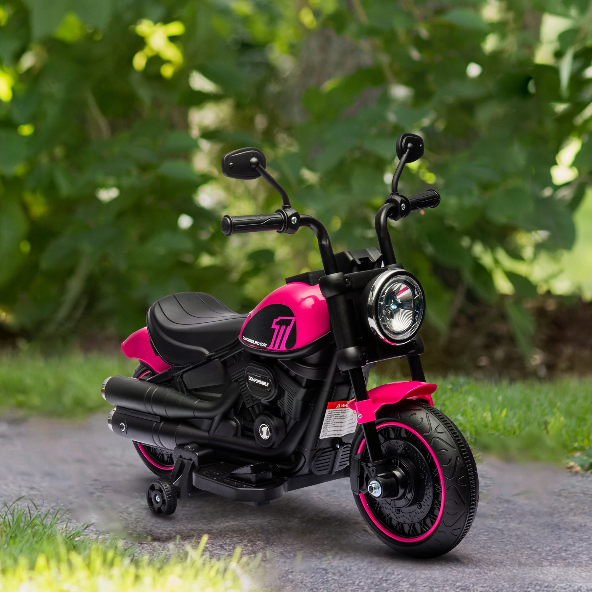 Moto giocattolo rosa su sentiero, sfondo verde, giornata soleggiata.