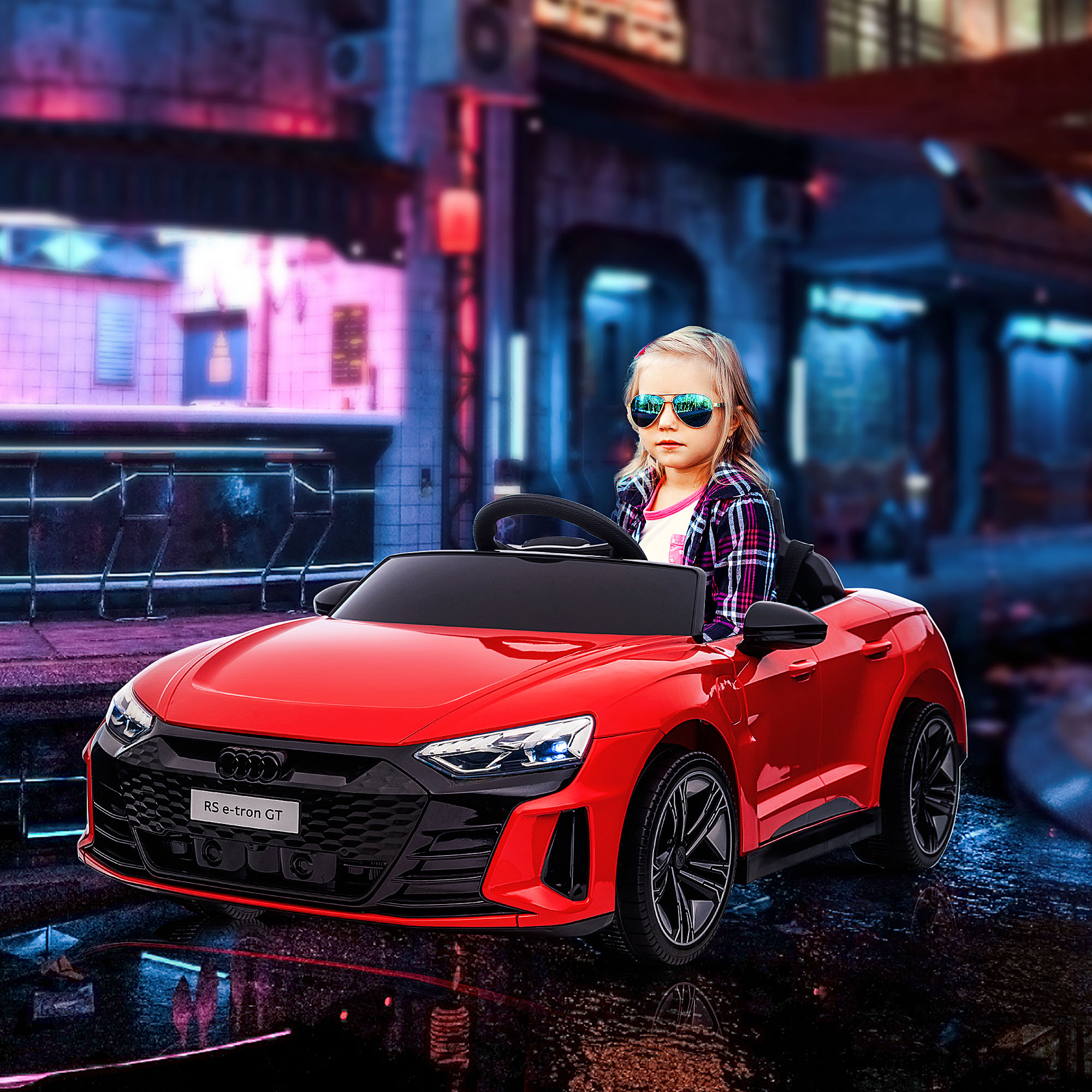 Un bambino con occhiali da sole in un'auto giocattolo rossa. Una scena urbana sullo sfondo.
