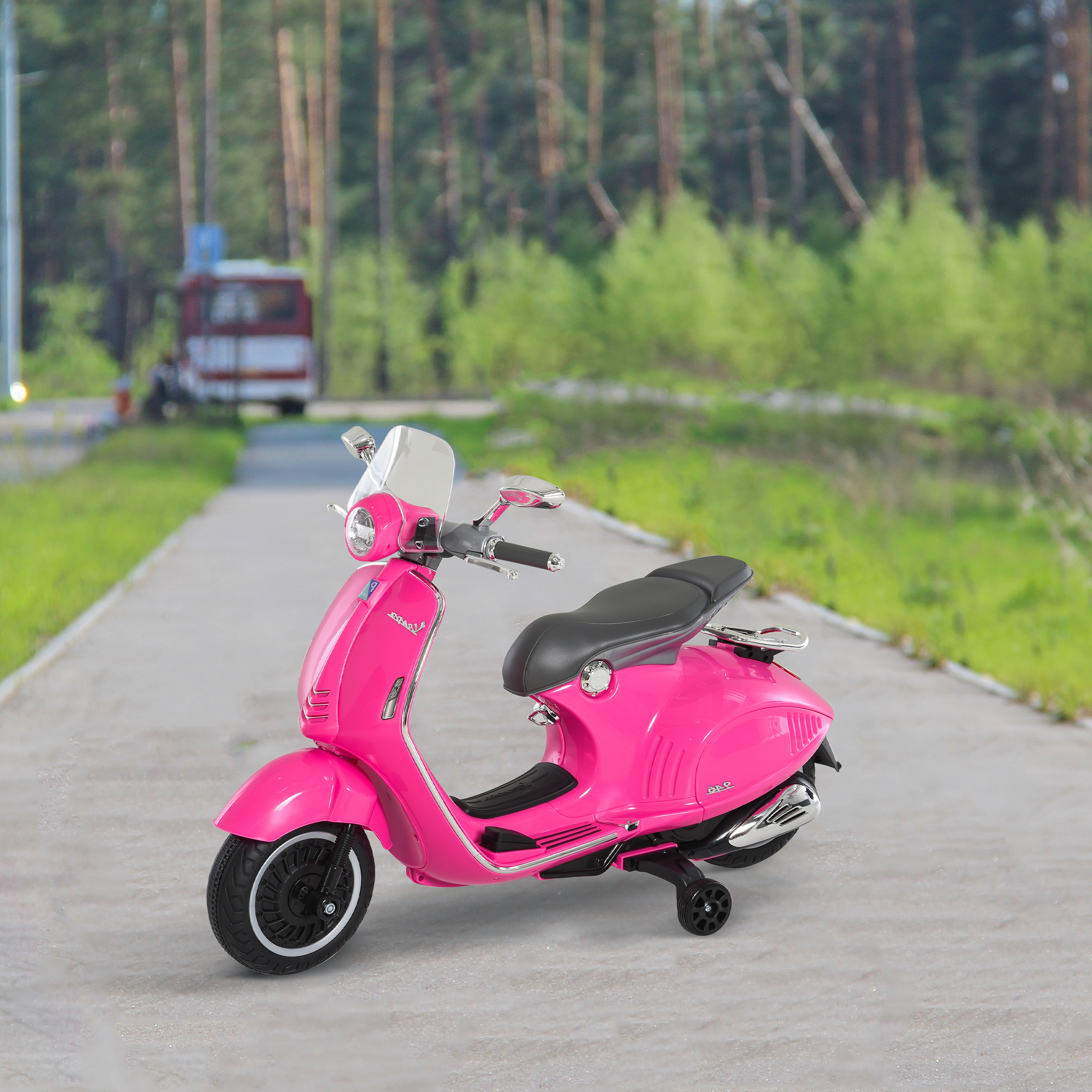 Scooter Vespa giocattolo rosa su un sentiero. Alberi verdi sullo sfondo, un edificio e un autobus.