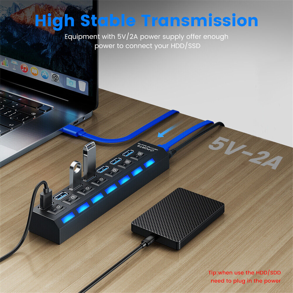 Ein schwarzer Hub mit USB-Anschlüssen, ein Laptop, eine Festplatte und ein USB-Kabel.