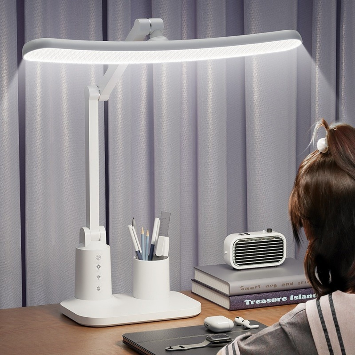 Weiße Schreibtischlampe mit Stifthalter, Büchern und Person im Hintergrund.