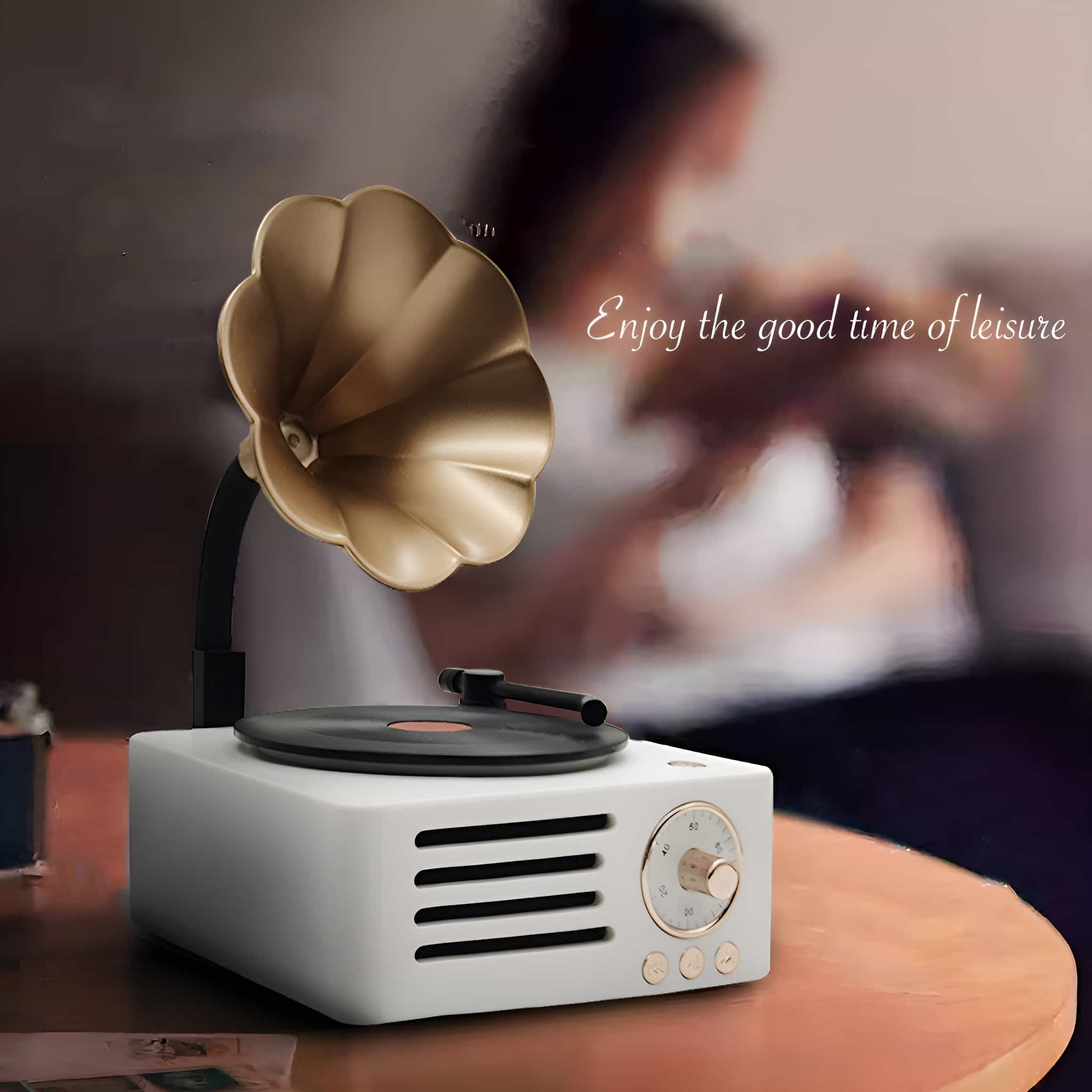 Ein weißer und goldener Lautsprecher im Grammophon-Stil. Text: Genieße die gute Zeit der Freizeit.
