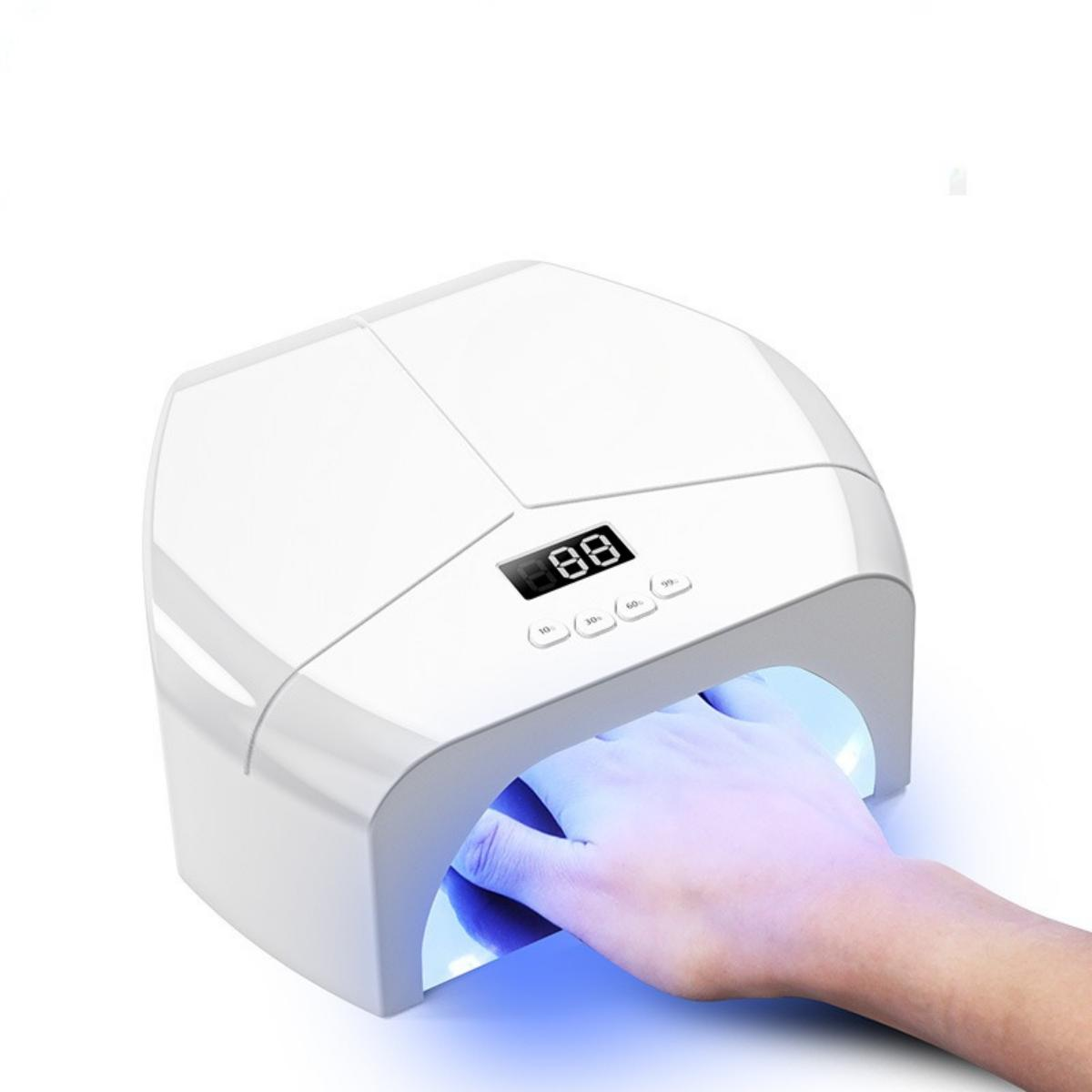 Eine weiße Nageltrocknungsmaschine mit einer Hand darin, die blaues Licht emittiert.