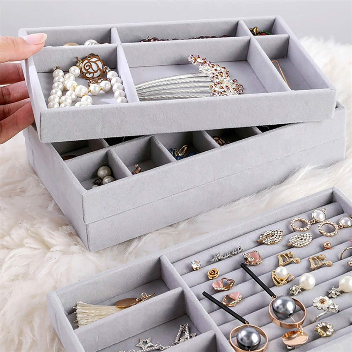 Schmuck-Organizer mit mehreren Fächern. Grau, mit Schmuck, Halsketten und Ringen.