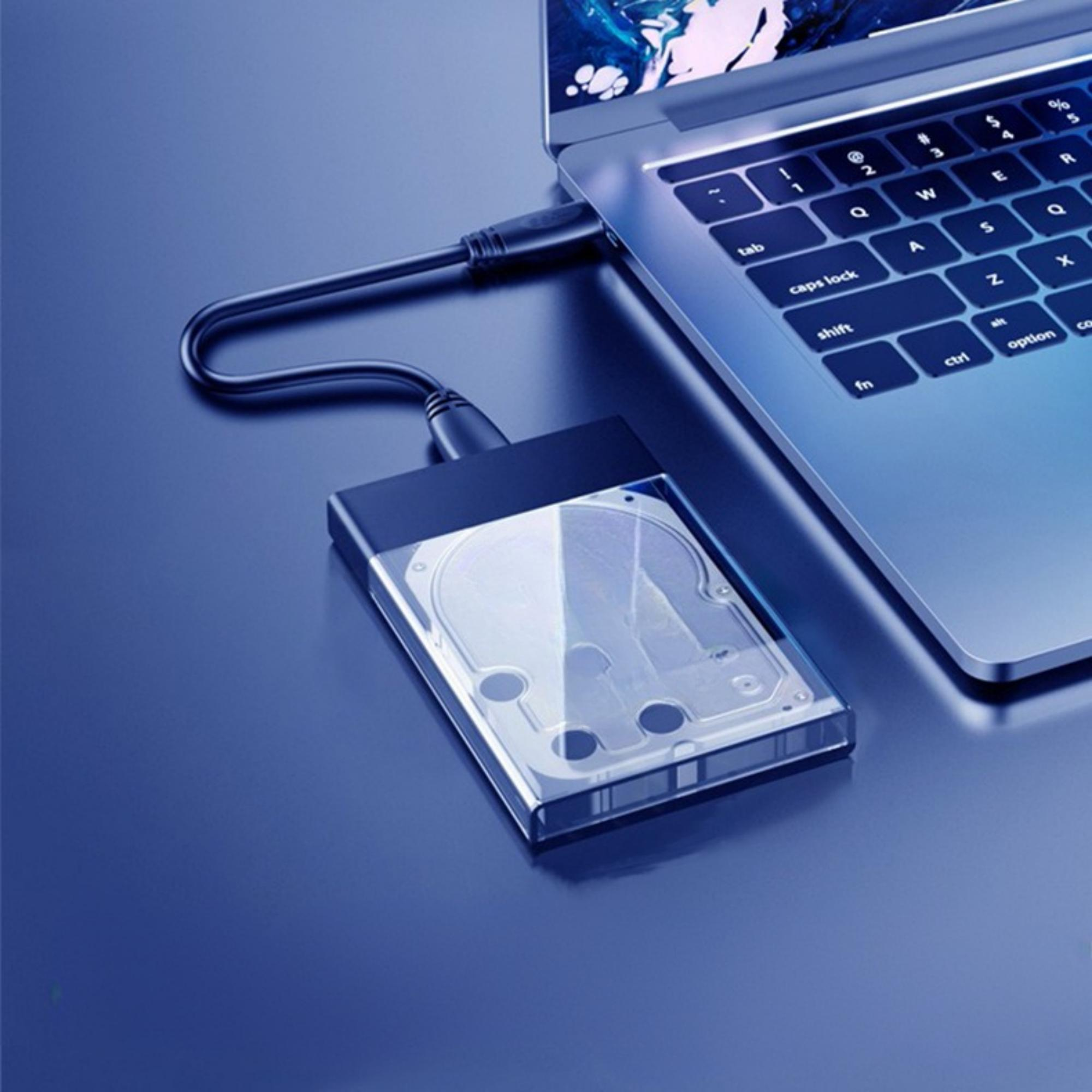Laptop, der über ein USB-Kabel mit einer externen Festplatte verbunden ist, beide auf blauem Untergrund.