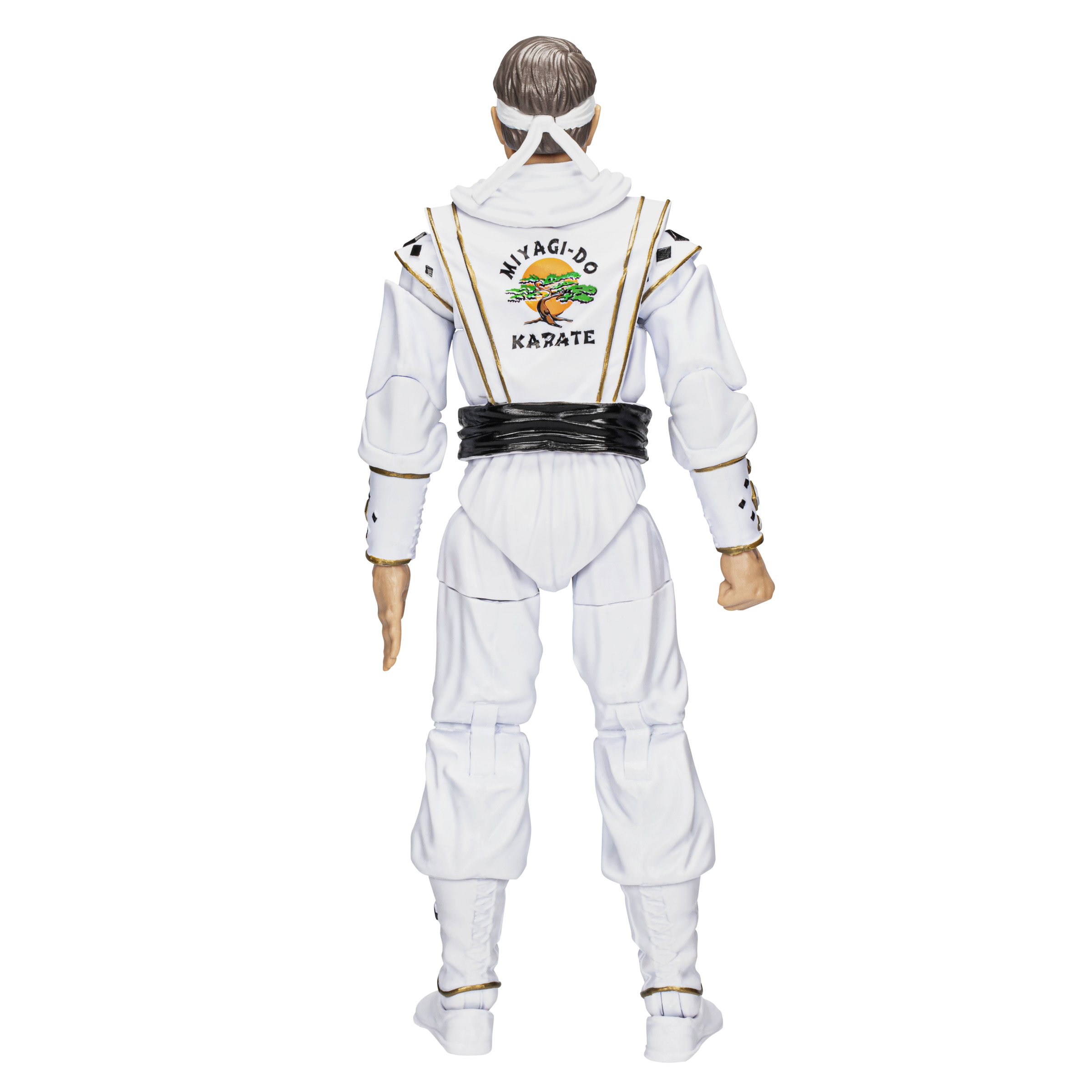 Action figure di un uomo in uniforme da karate bianca, con toppa sulla schiena, su sfondo bianco.