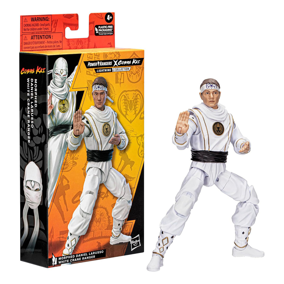 Action figure di un uomo in uniforme da karate bianca con una scatola accanto.