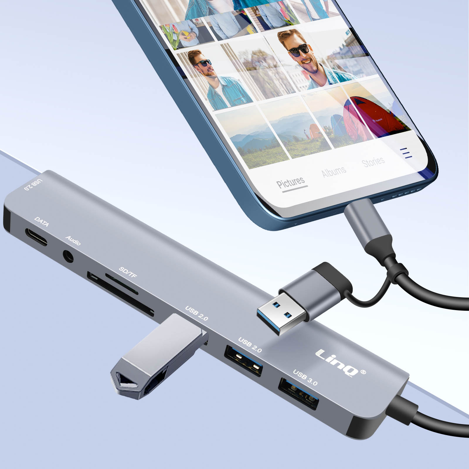 Un hub USB argentato collegato a un telefono. L'hub ha più porte e un cavo USB.