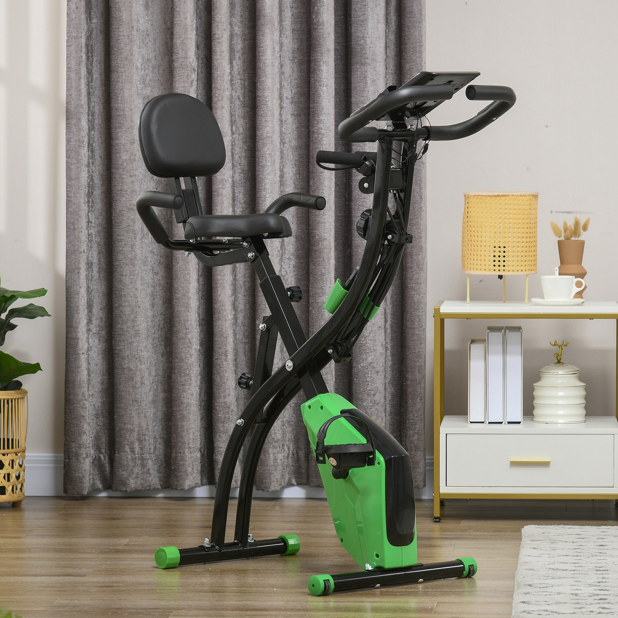 Cyclette nera e verde in una stanza. La bici ha schienale e display.