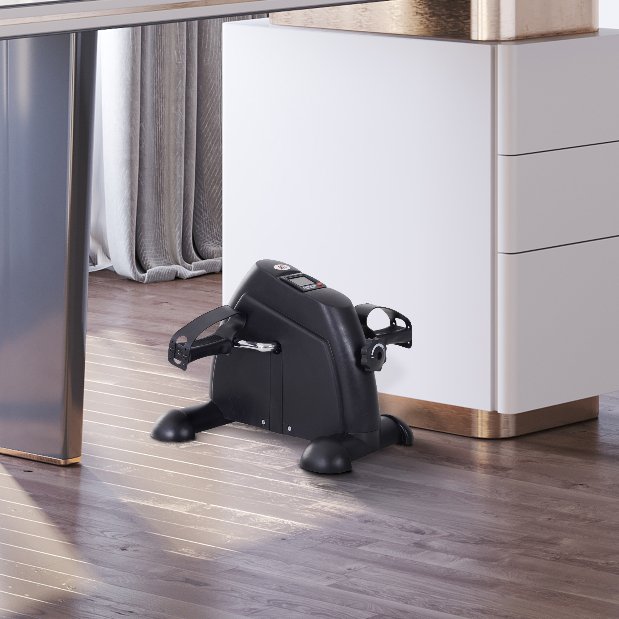 Ein schwarzes Trainingsfahrrad vor einem weißen Schrank und einem Schreibtischbein.