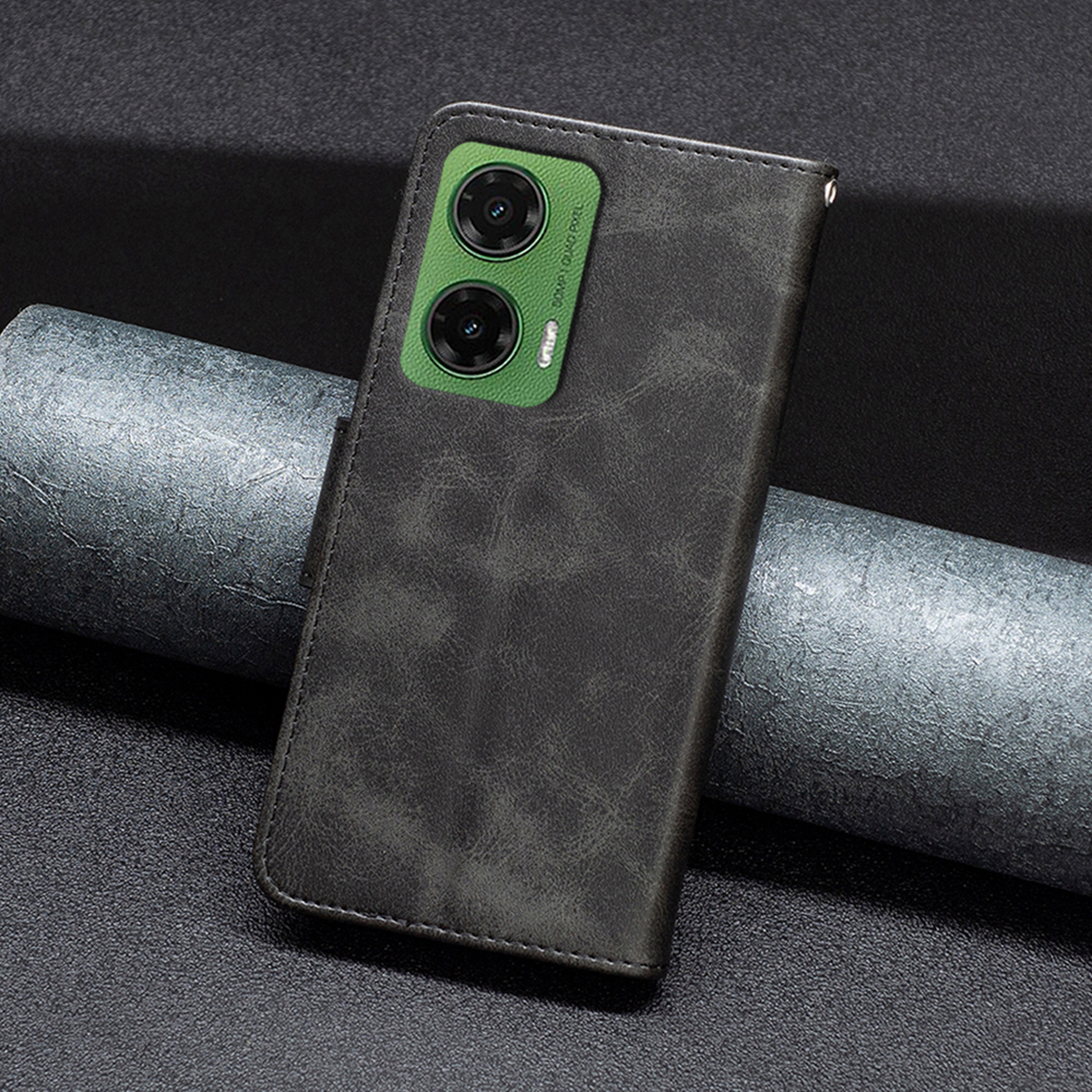 Donkergrijze telefoonhoes met telefoon erin. Groene cameramodule zichtbaar.